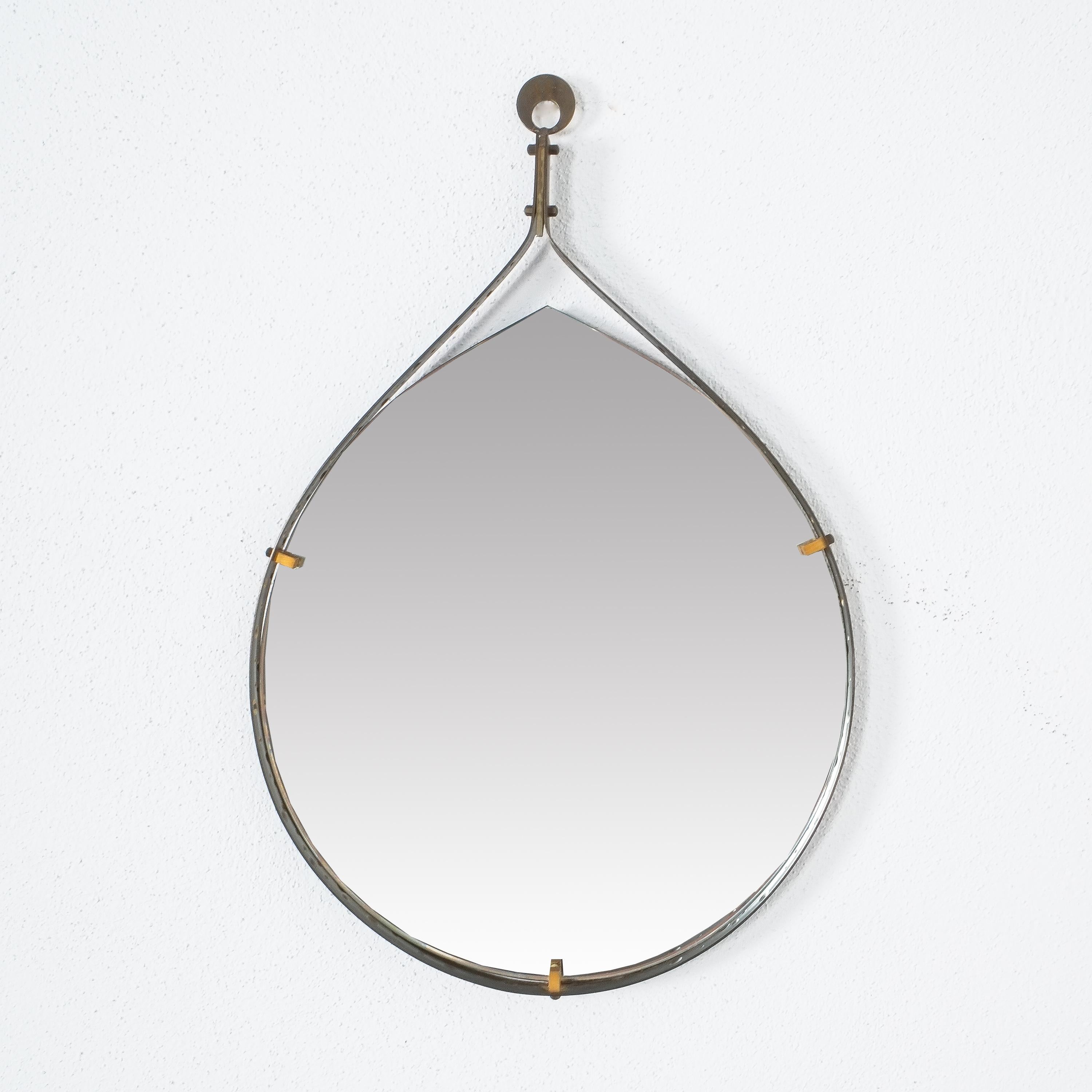 Teardrop iron mirror, Italy, circa 1955

1950s Italian iron and brass tear dropped shaped mirror with perforated brass detail within the edge.
Brass hardware. It’s in great condition, the mirror glass shows no staining or scratches.
Dimensions