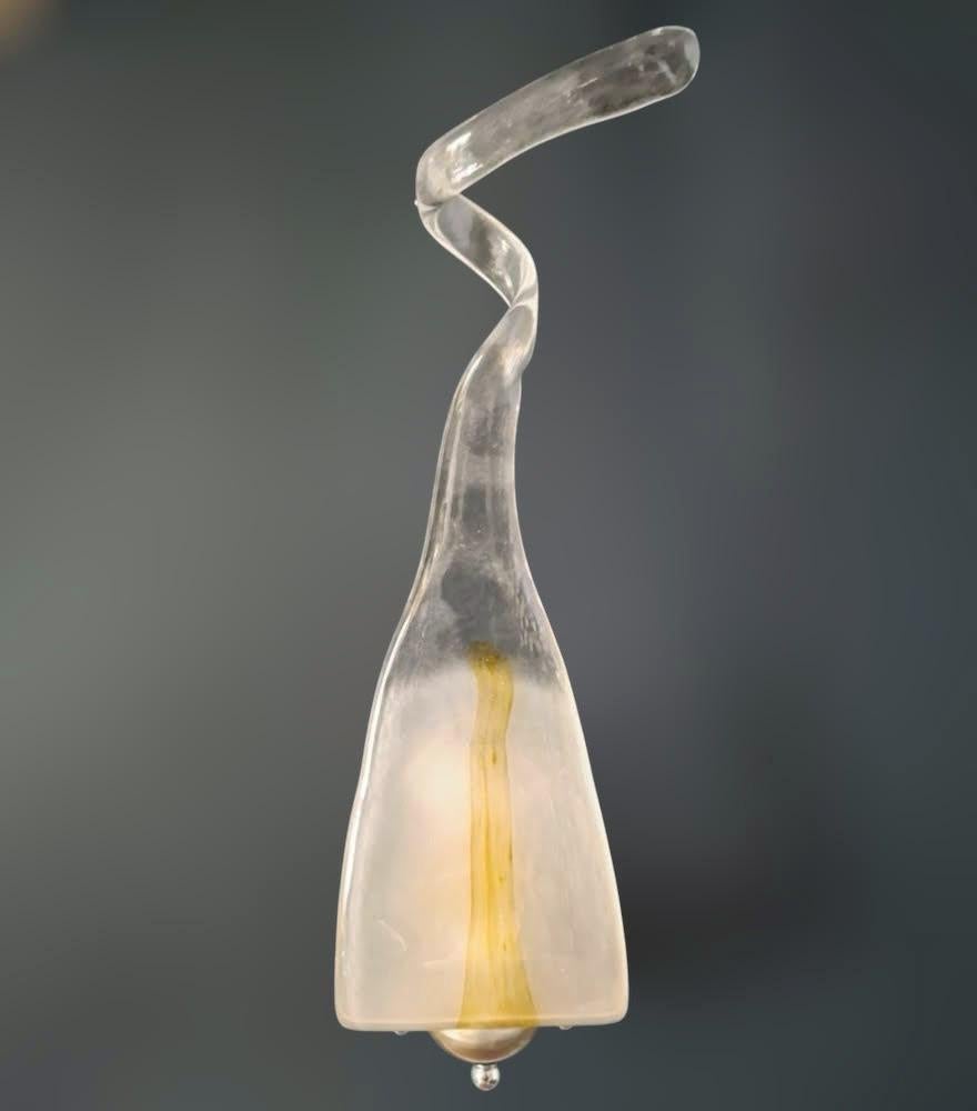 Vintage Italian wall light with a teardrop shaped Murano glass diffuser blown in clear and white color decorated with amber, mounted on a straight arm in satin silver color / Made in Italy by Mazzega, circa 1960s
Measures: height 20.5 inches, width