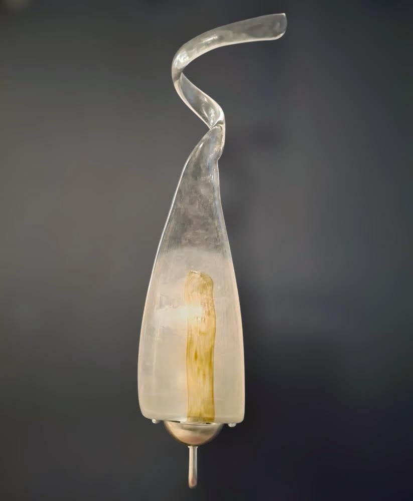 Vintage Italian wall light with a teardrop shaped Murano glass diffuser blown in clear and white color decorated with amber, mounted on a curved arm in satin silver color / Made in Italy by Mazzega, circa 1960s
Measures: height 20 inches, width 4.5