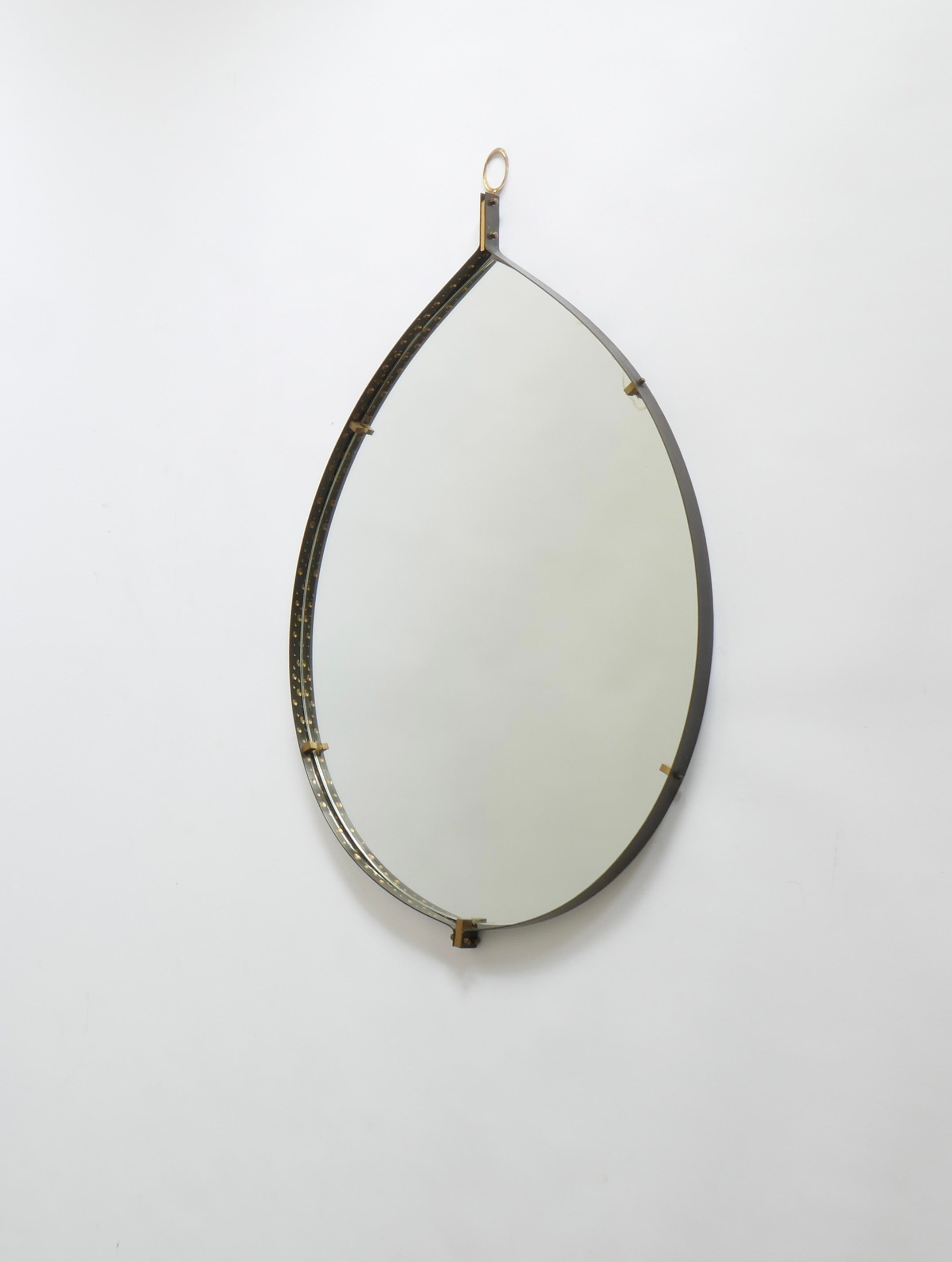 A beautiful handmade teardrop-shaped mirror, within a hammered iron frame, embellished within brass hardware detail.