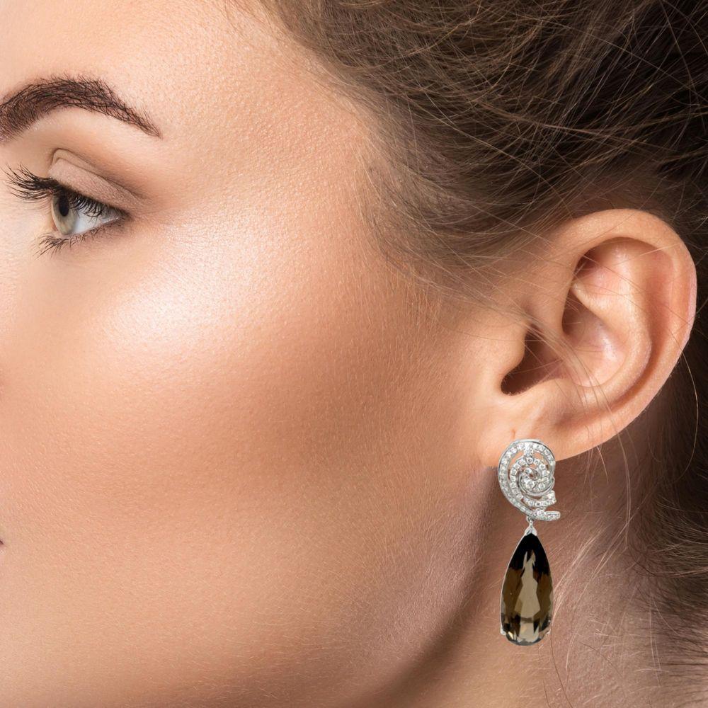 These beautiful Dangling earrings have over 18 carats of deep brown Smokey Topaz set in 14 karat white gold. These gorgeous Pear shape stones are 25x10 mm with omega backs. These earrings will be the talk of town when you wear them for that special
