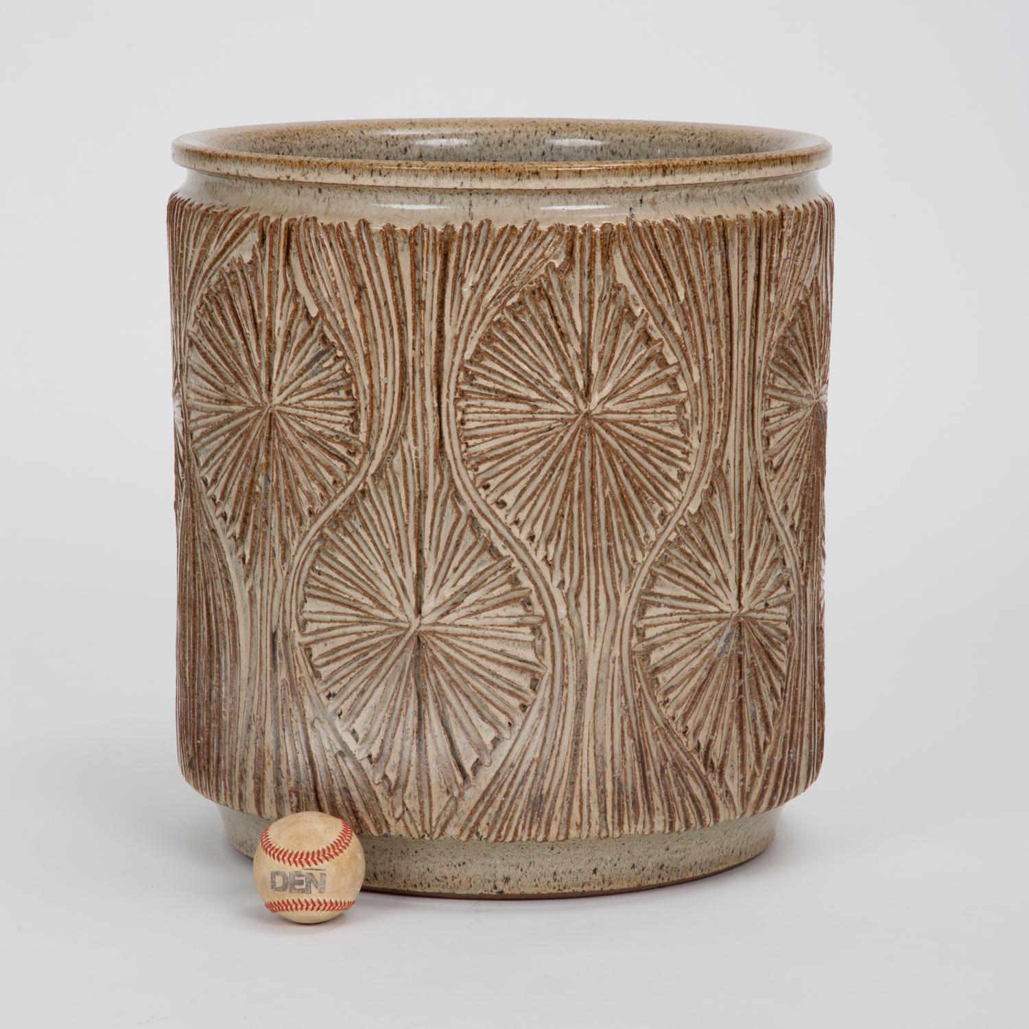 A cylindrical planter from Earthgender, David Cressey and Robert Maxwell’s early 1970s project. This example is incised in the “Teardrop Sunburst” design with interlocking curved gestures separating a pattern of lines radiating from a central point.