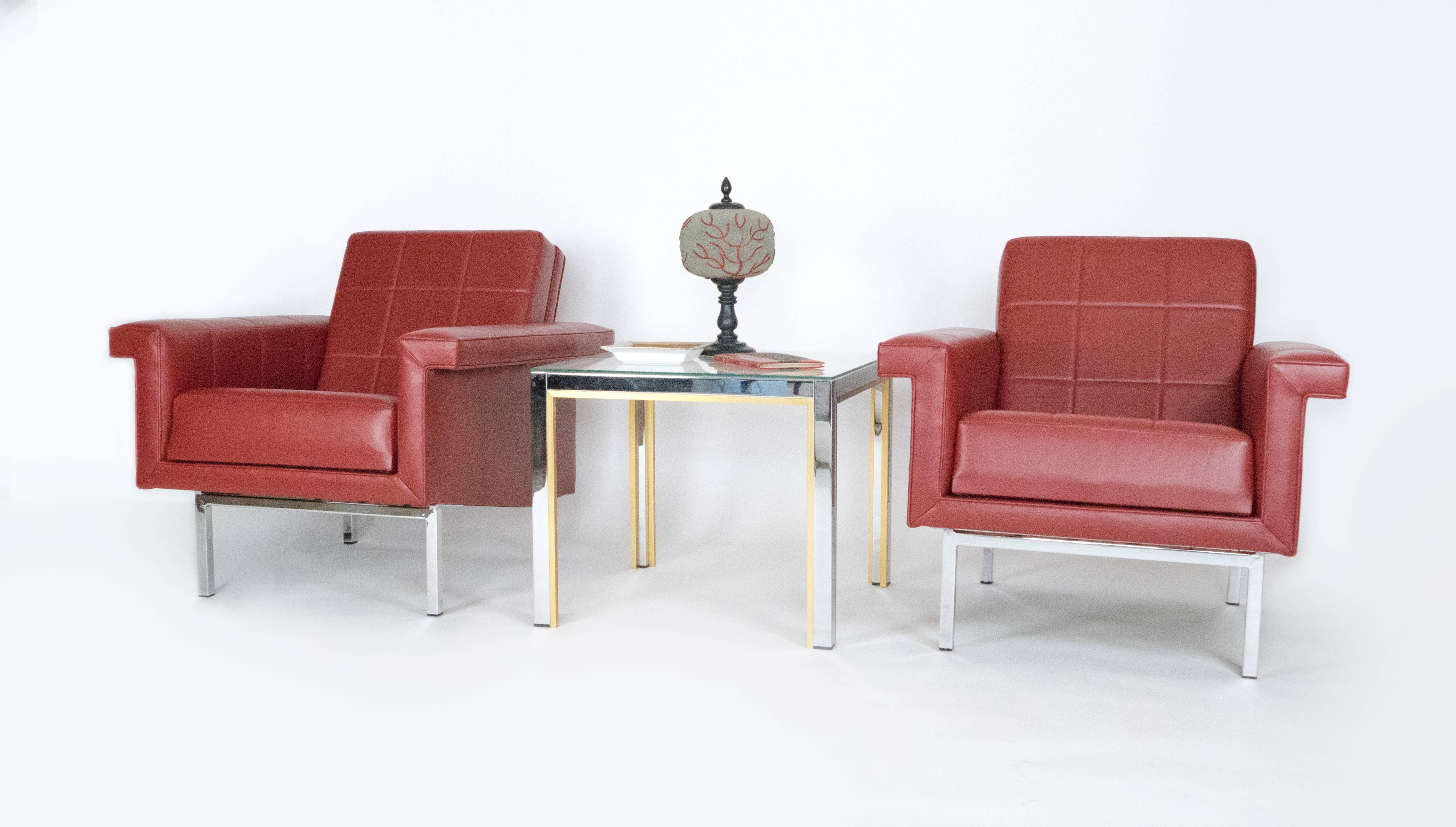 Die Linien dieser tief sitzenden Sessel sind klar und modern, die Stühle sind sehr bequem. Das gesteppte Design und die verchromten, kantigen Beine erinnern an das französische Design der 1970er Jahre. Diese Sessel sind mit einem chilifarbenen Leder