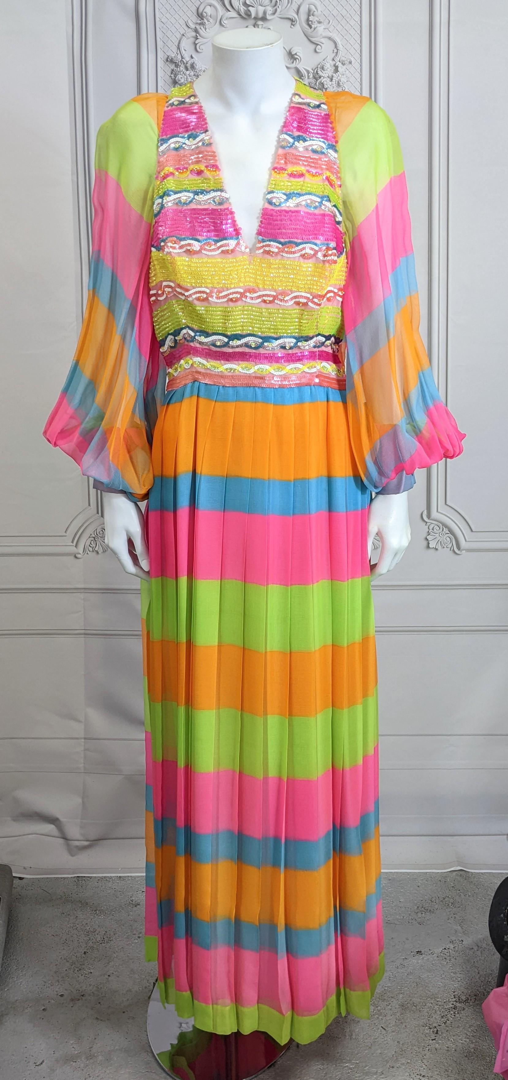 Amazing Technicolor Silk Chiffon and Sequined Gown from the 1970's. Designer label has been removed but quality is beautiful. Vibrant tropical striped silk chiffon with matching tonal sequin bodice and waist band.
Full pleated skirt as well as full