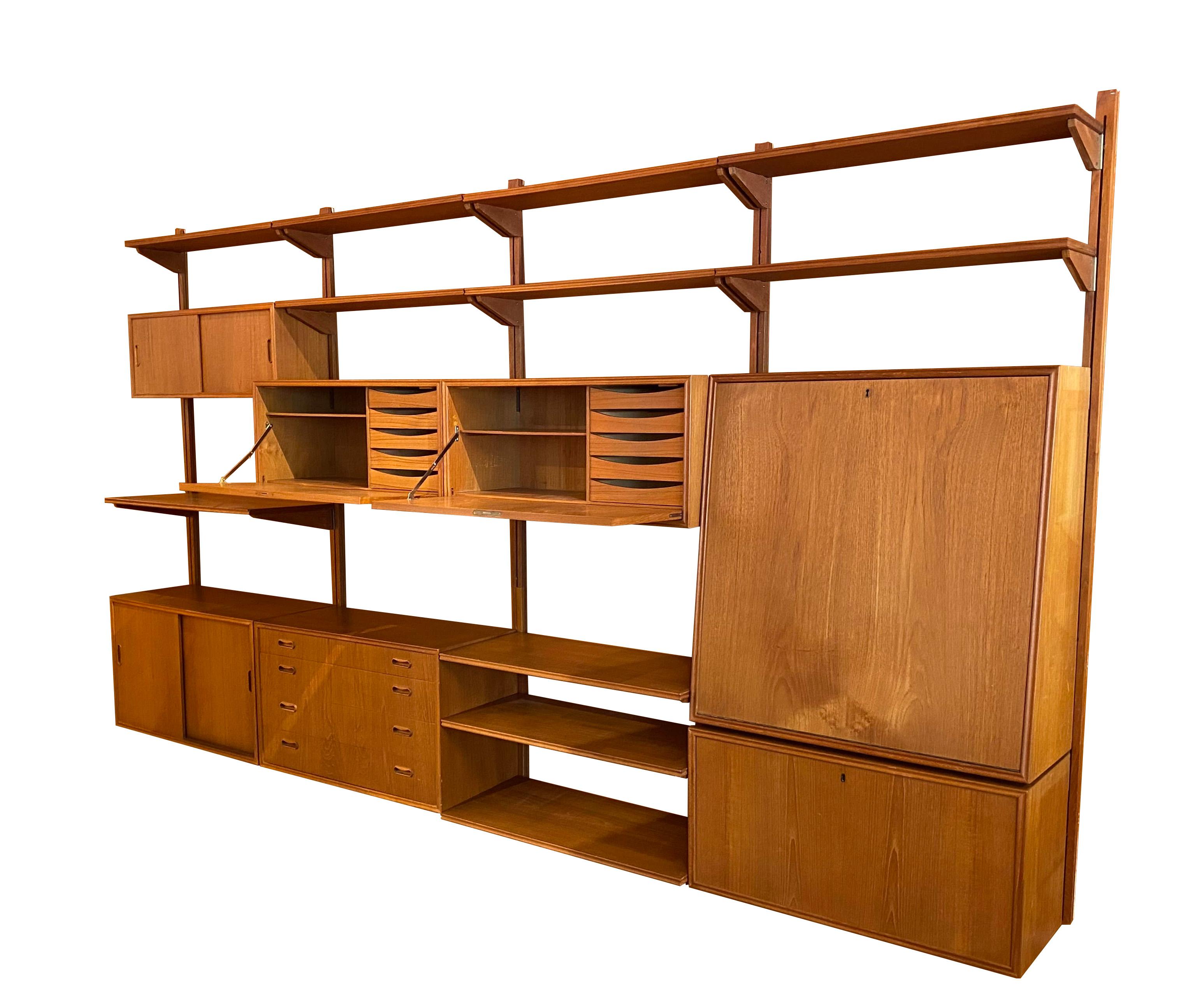Parete attrezzata in teak nello stile di Poul Cadovius. Design scandinavo, circa 1960. 

La libreria comprende 
- 5 ripiani: H. H. 183,5 cm
- 7 ripiani: L: 80 x P: 22 cm
- 4 ripiani: L: 80 x P: 35 / spessore: 2 cm 
- 1 modulo di segreteria : 
- 1