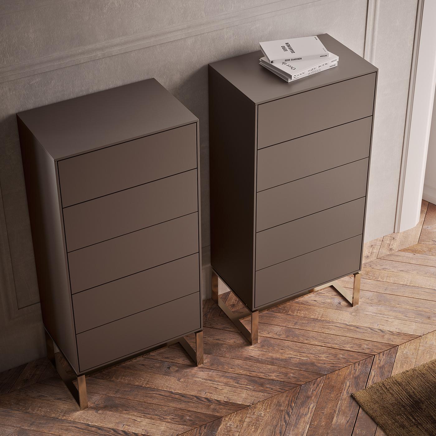 A sleek solution offering ample storage space, this chest of drawers stands out for its rigorous silhouette in gray-lacquered MDF. Organized in five drawers equipped with a soft-close system, the storage unit towers over the open steel base are