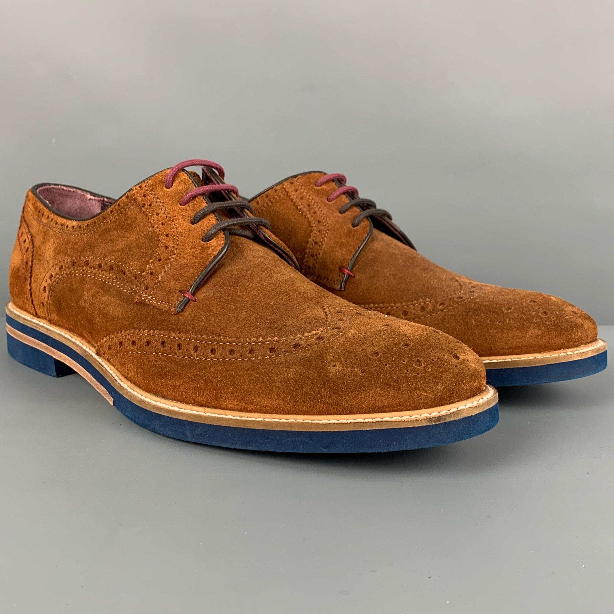 TED BAKER shoes comes in a brown perforated suede featuring a wingtip style, contrast stitching, and a two toned lace up closure. Made in Italy. 

Excellent Pre-Owned Condition.
Marked: 11

Outsole: 12.5 in. x 4.5 in. 