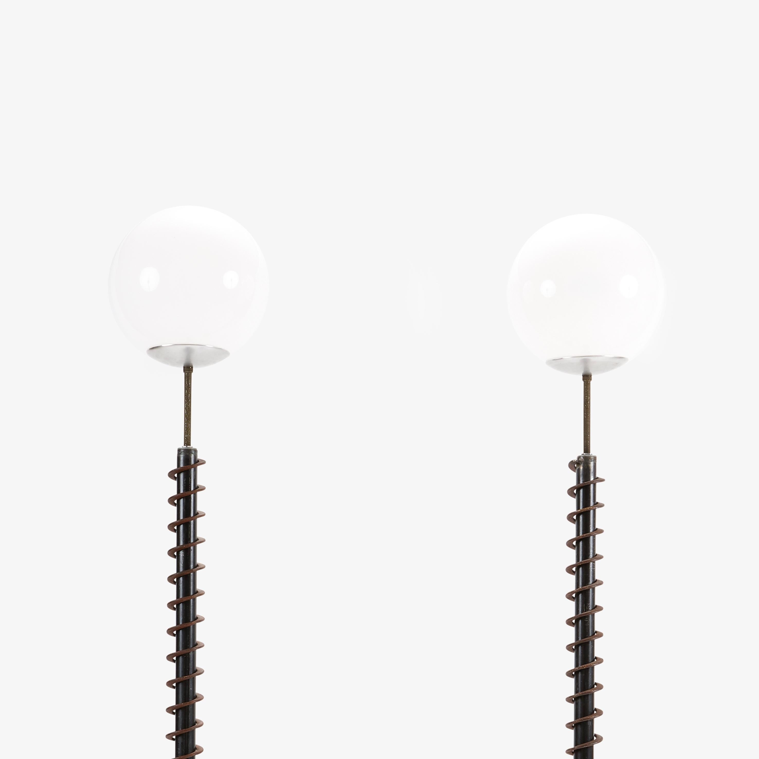 Pair of floor lamps by renowned Chicago artist Ted Harris. Lamps are constructed from repurposed industrial machinery parts. They are touch activated with three levels of illumination, by tapping the metal base of the globe. 

78” H, 11” D base,