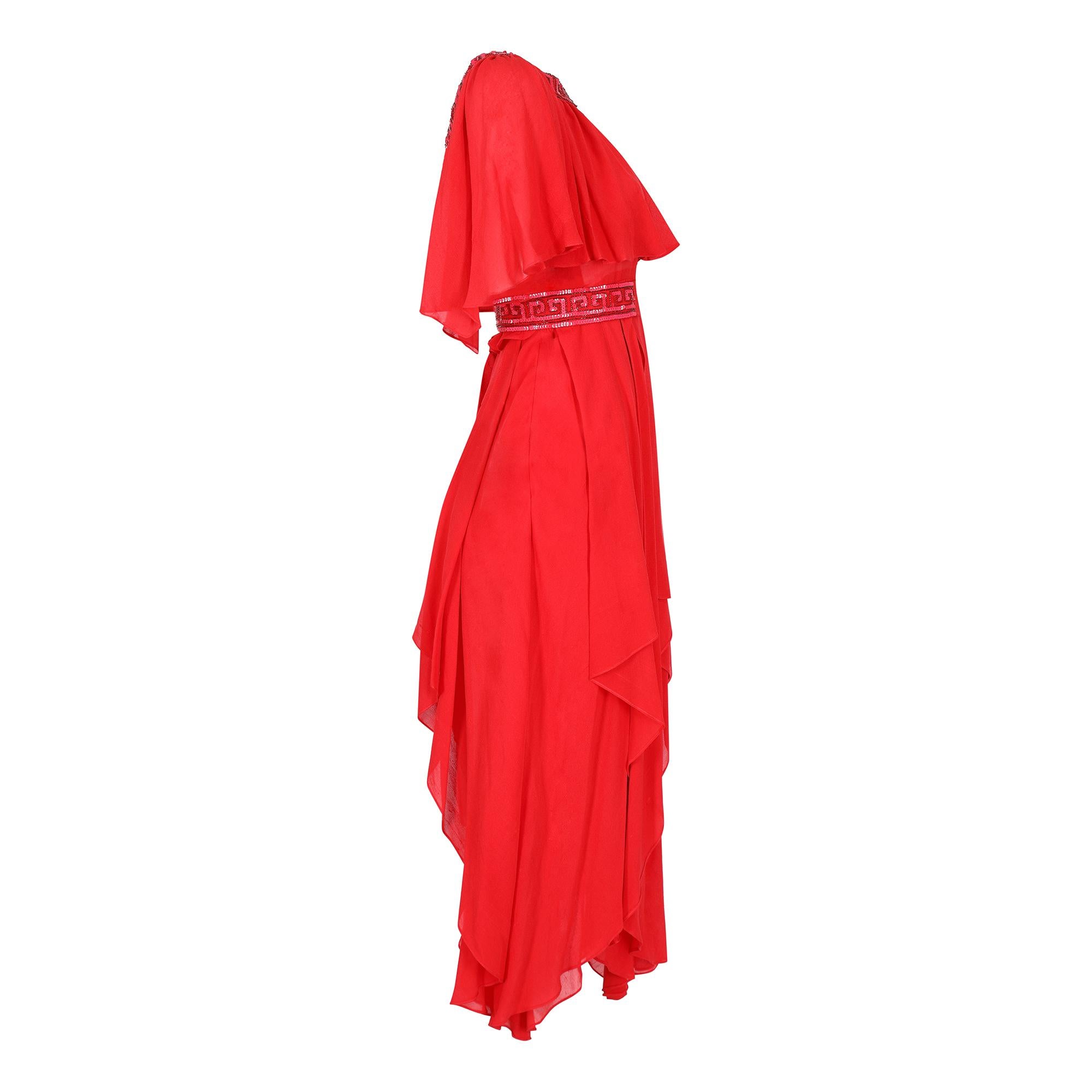 This Ted Lapidus dress is circa 1977 and is made entirely by hand; this label is probably the haute couture label. The beautiful flame red, raw silk georgette fabric is both striking and feminine. The dress features an embellished, wide scoop