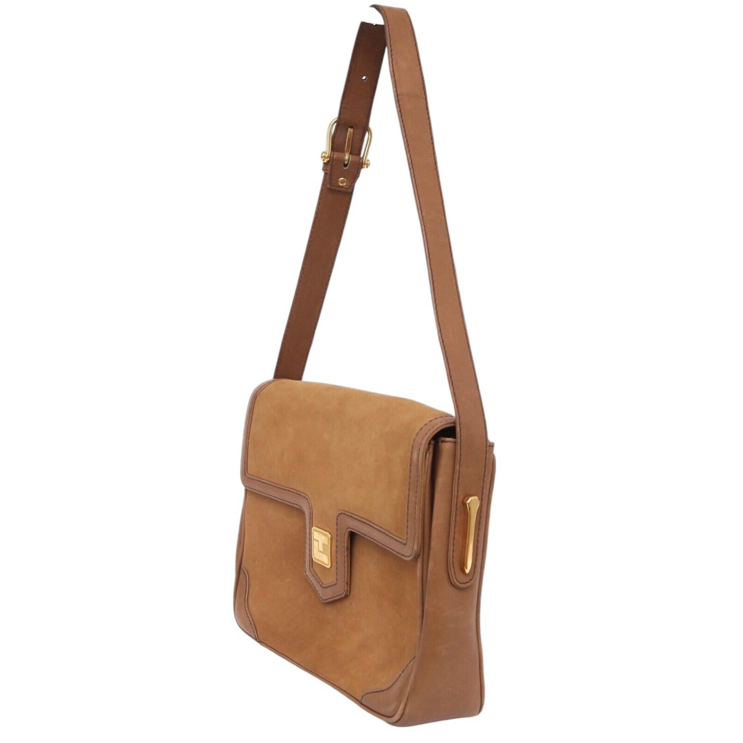 BOLSO VINTAGE TED LAPIDUS DE ANTE, AUTÉNTICO Y GARANTIZADO

- Diseño:
  - Exterior de ante marrón con ribetes de cuero marrón.
  - Costura superior.
  - Solapa frontal con cierre a presión.
  - Logotipo TL dorado en la solapa.
  - Interior de