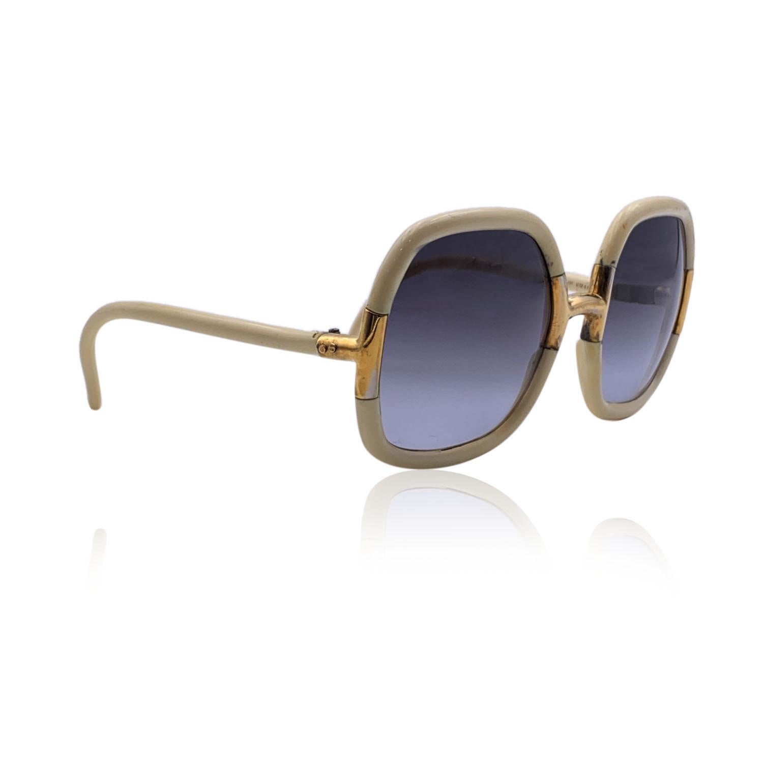 Vintage-Sonnenbrille in Übergröße aus den 70ern von TED LAPIDUS, mod.G 20. Hellbeiger Rahmen, akzentuiert mit goldenen Metallelementen. Hellgraue Gläser mit Farbverlauf (100% UV-Schutz). Hergestellt in Frankreich

Einzelheiten

MATERIAL: