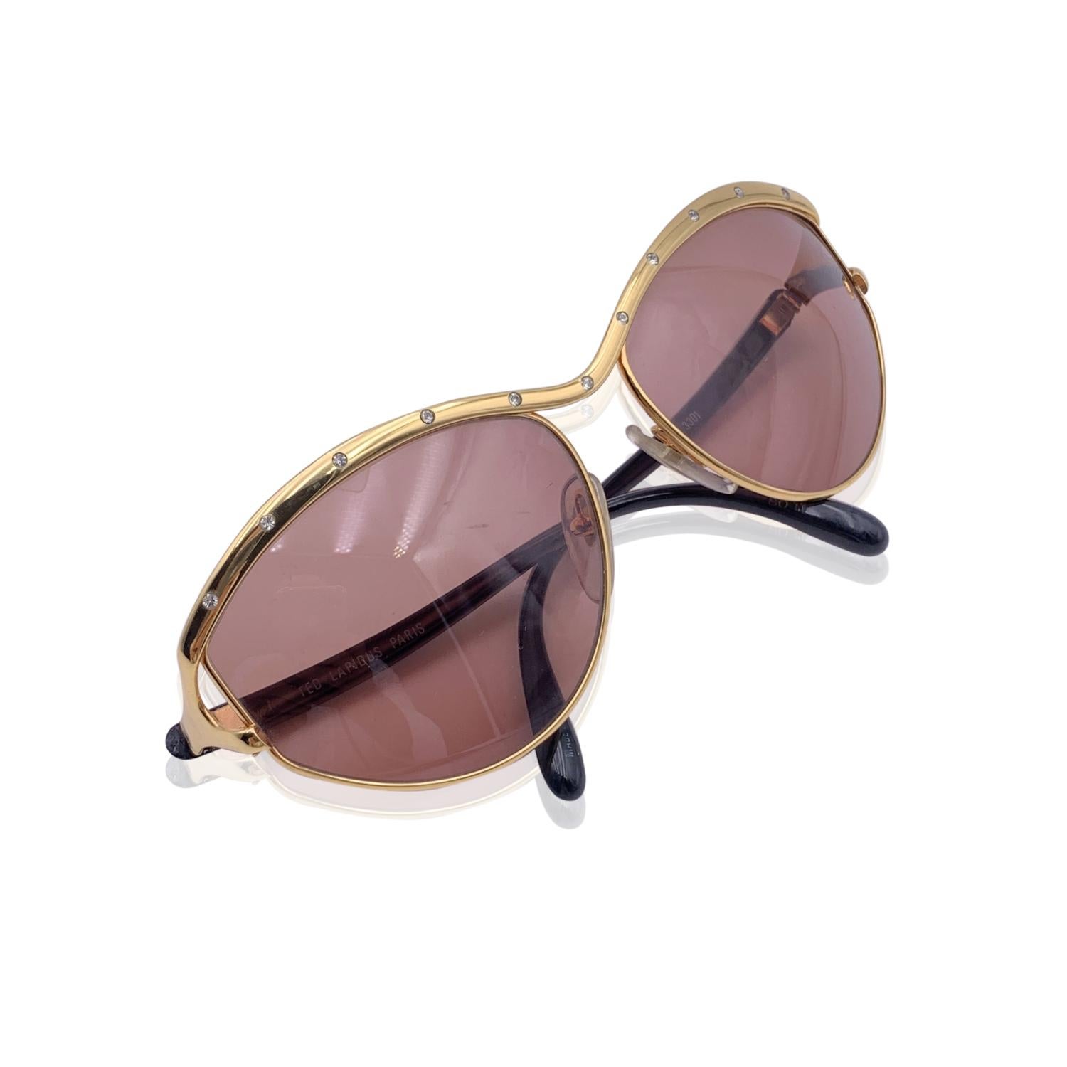 Oversized, gorgeous one-of-a-kind sunglasses by Ted Lapidus, Paris, mod. TL 3301. Gold metal frame with black acetate arms. Rhinestones finish on the top Brown original lenses.

Details

MATERIAL: Metal

COLOR: Gold

MODEL: TL 3301

GENDER: