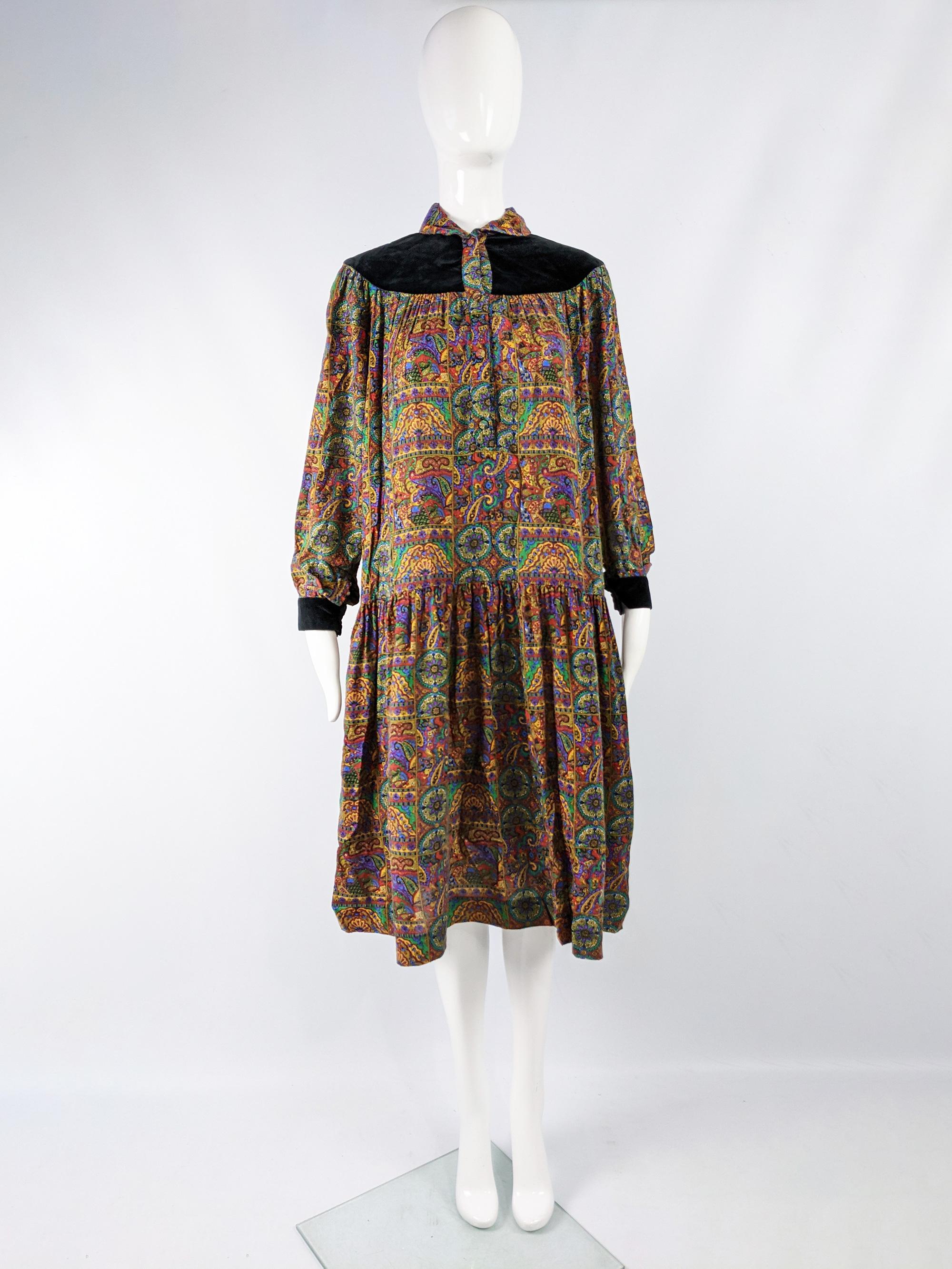 A beautiful vintage smock / tent dress from the 70s by luxury French fashion designer, Ted Lapidus. In a bright, multicolored paisley print fabric with a black velvet yoke and a boho style oversized fit and long sleeves. 

Size: Marked EU 40 which