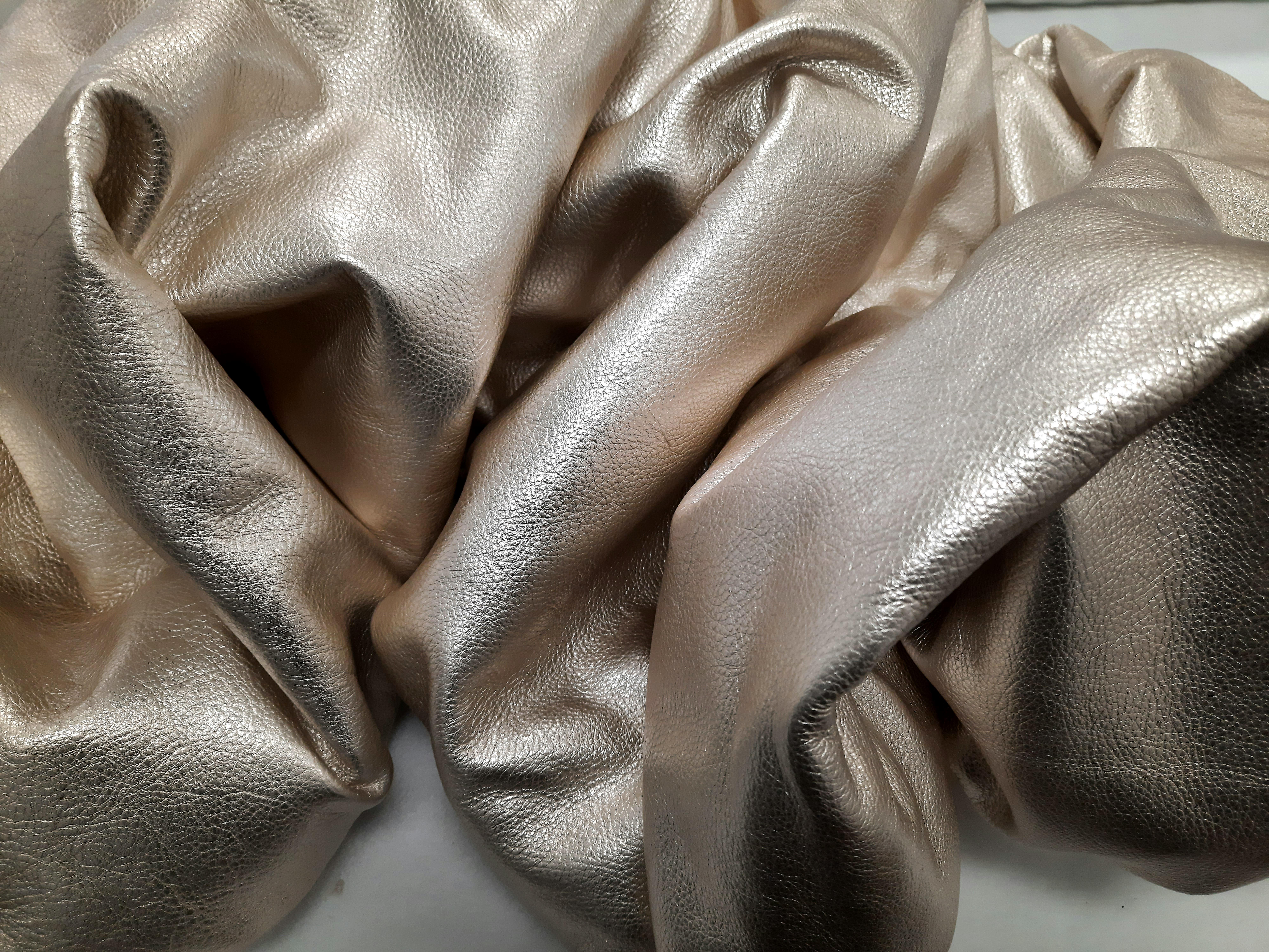 Drape 114 Champagne by Ted VanCleave transforms a single sheet of metallic leather into a sinuous, process-driven study of material and form. Its creased, crinkled, and softly wrinkled surface catches the light with a soft champagne glow—slick,