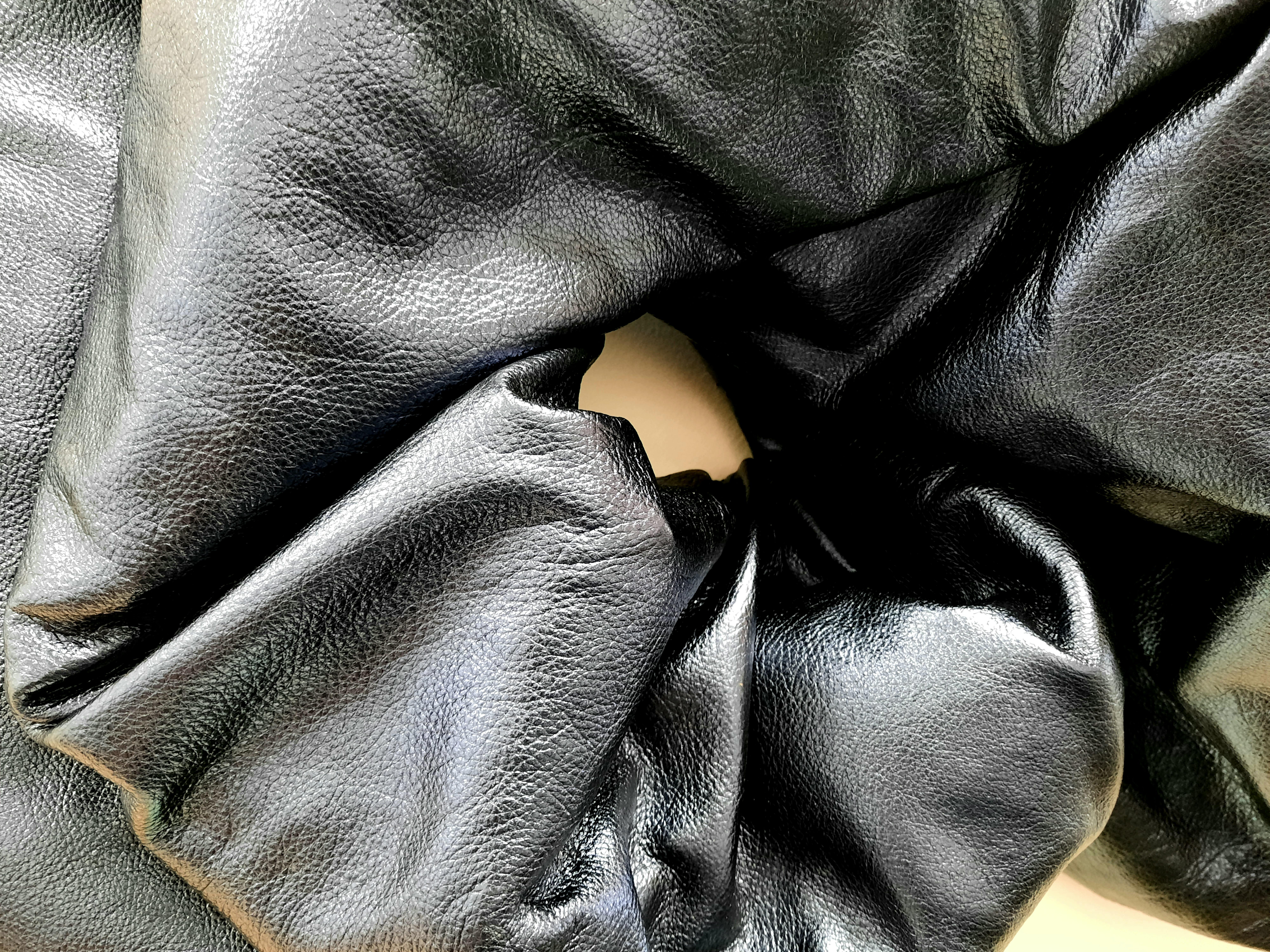 Drape in Midnight Blue by Ted VanCleave transforms a single sheet of metallic leather into a sinuous, process-driven study of material and form. Its creased, crinkled, and softly wrinkled surface catches the light with a vivid electric blue