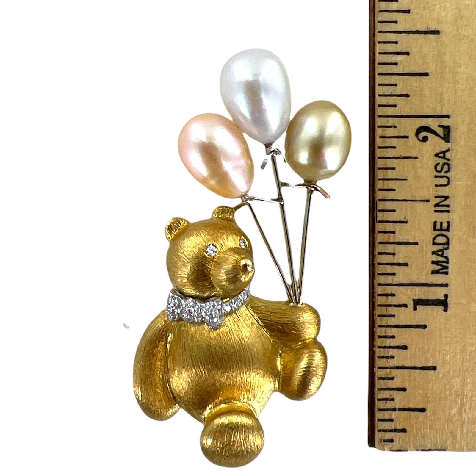 The brooch depicts an adorablle teddy bear with diamond collar and eyes carrying balloons. The pin features 45 round brilliant cut diamonds weighing approximately .25 CTW and graded F-G color and VS clarity. The bear is holding three pearl balloons