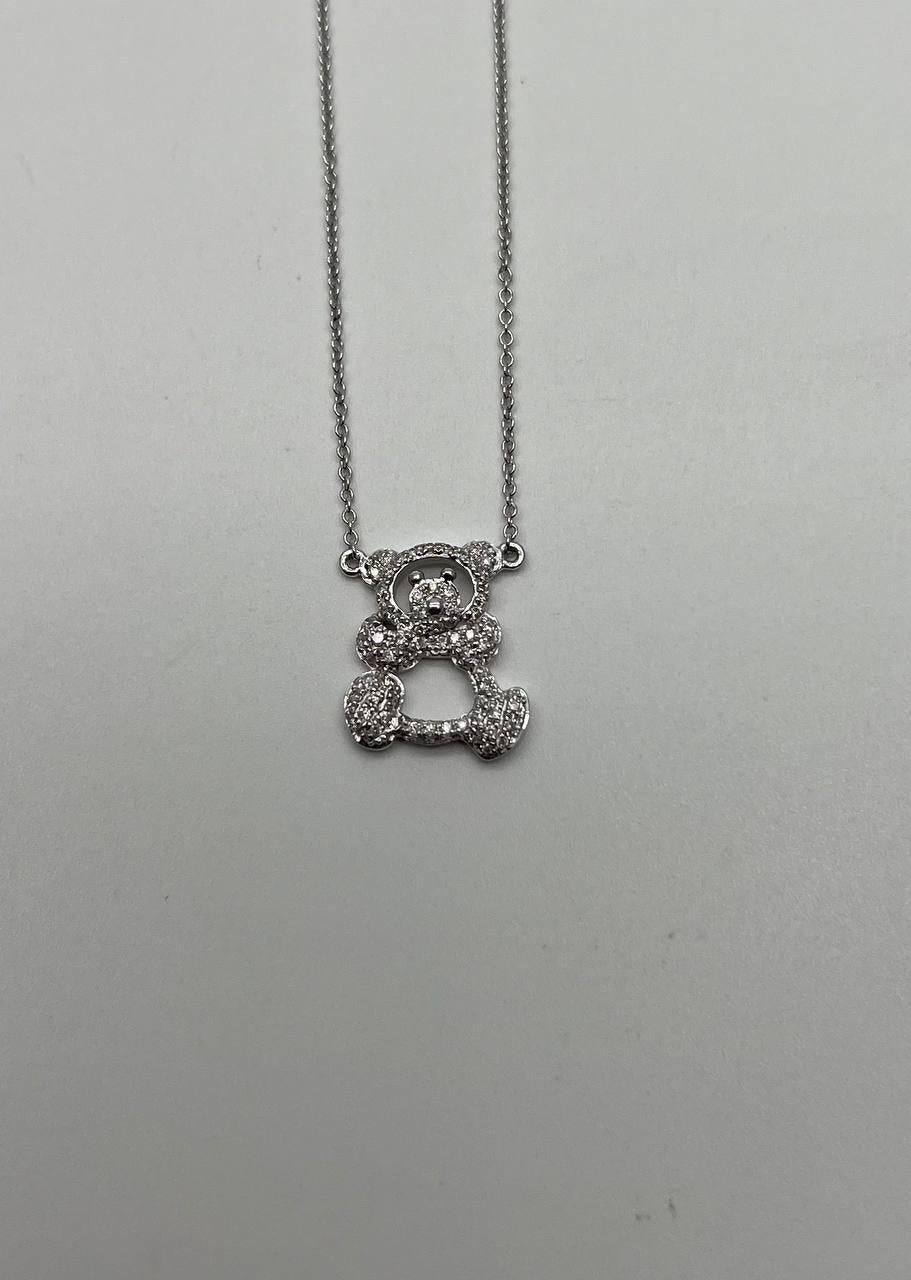Découvrez le charme fantaisiste de ce collier à pendentif ourson. Conçu en or blanc 18 carats, le collier comporte environ 0,32 carats de diamants blancs. Le pendentif présente un ourson ludique, incrusté de diamants pavés qui ajoutent une touche
