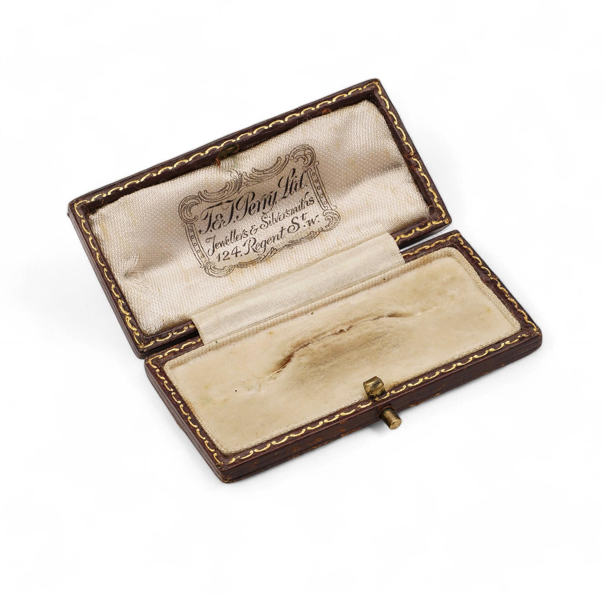 Une boîte à broches rectangulaire compacte avec un extérieur robuste et un intérieur en velours doux. La marque apposée sur le couvercle reflète l'héritage du joaillier.
Compacte et pratique, cette boîte à broches T.E.I. Perry offre un rangement sûr