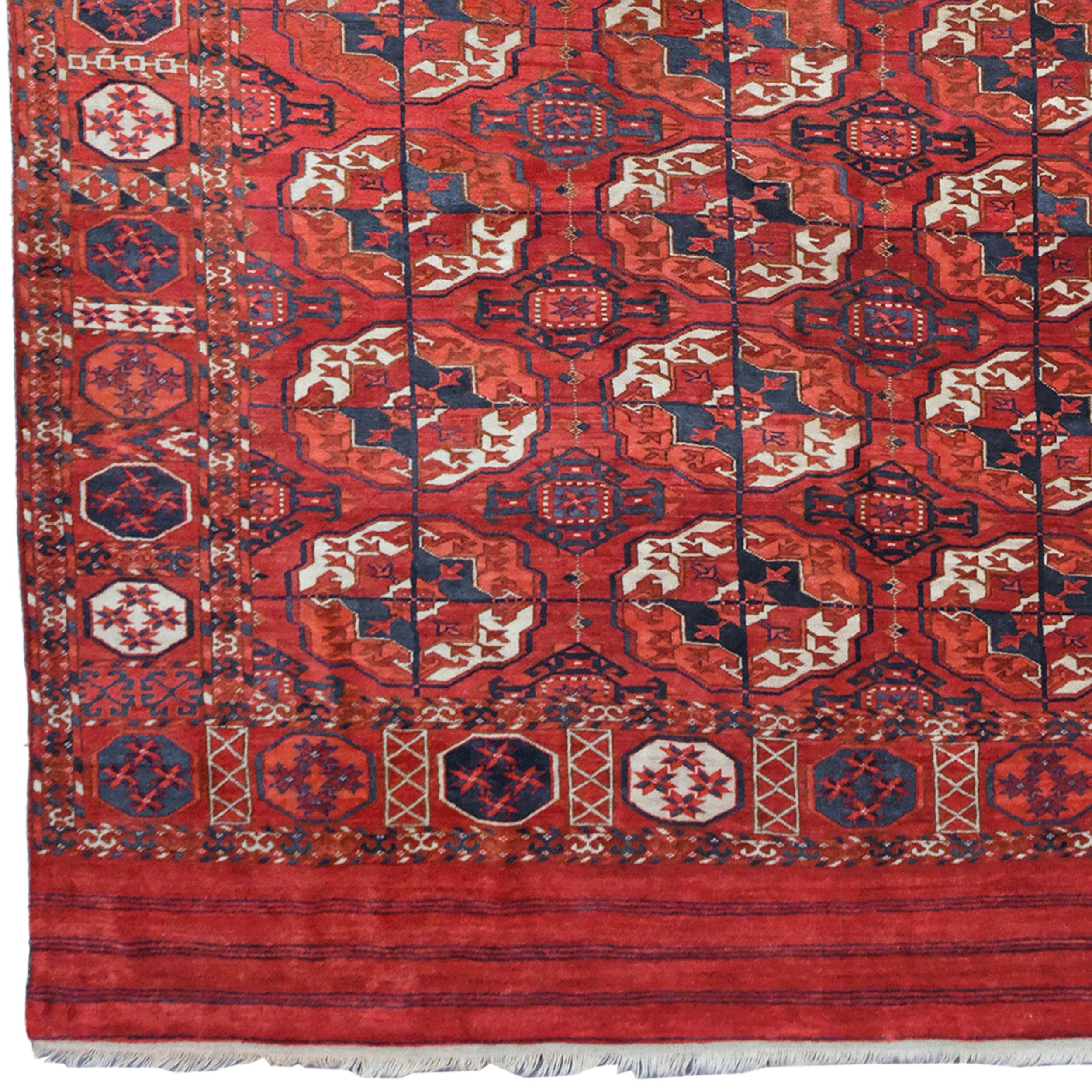 Un excellent tapis principal turkmène Tekke de petite taille. Le champ rouge garance clair est orné de grands guls ronds Tekke bien dessinés. La bordure est composée d'un motif de soleil et d'octogones. Notez les panneaux elem empilés à chaque