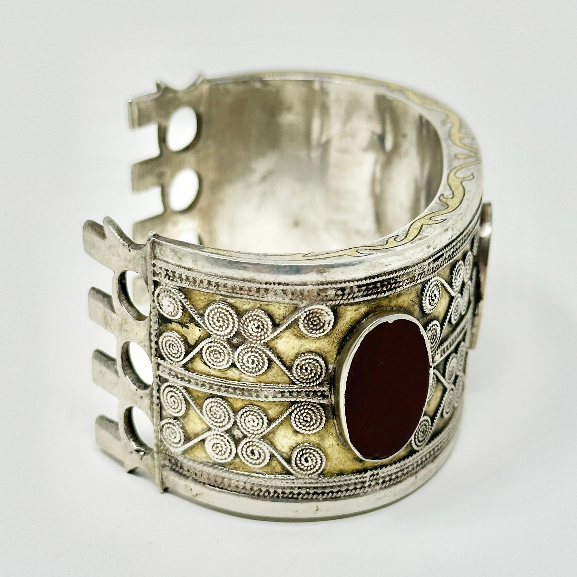Tekke Turkoman Carnelian and Silver Cuff

A vintage carnelian and silver four-pronged cuff from the Tekke Turkoman with applied silver scrolls and gilding. Interior diameter is 2.5 inches wide, 1-3/8 inches high with a 1.5 inch gap; weight is 110