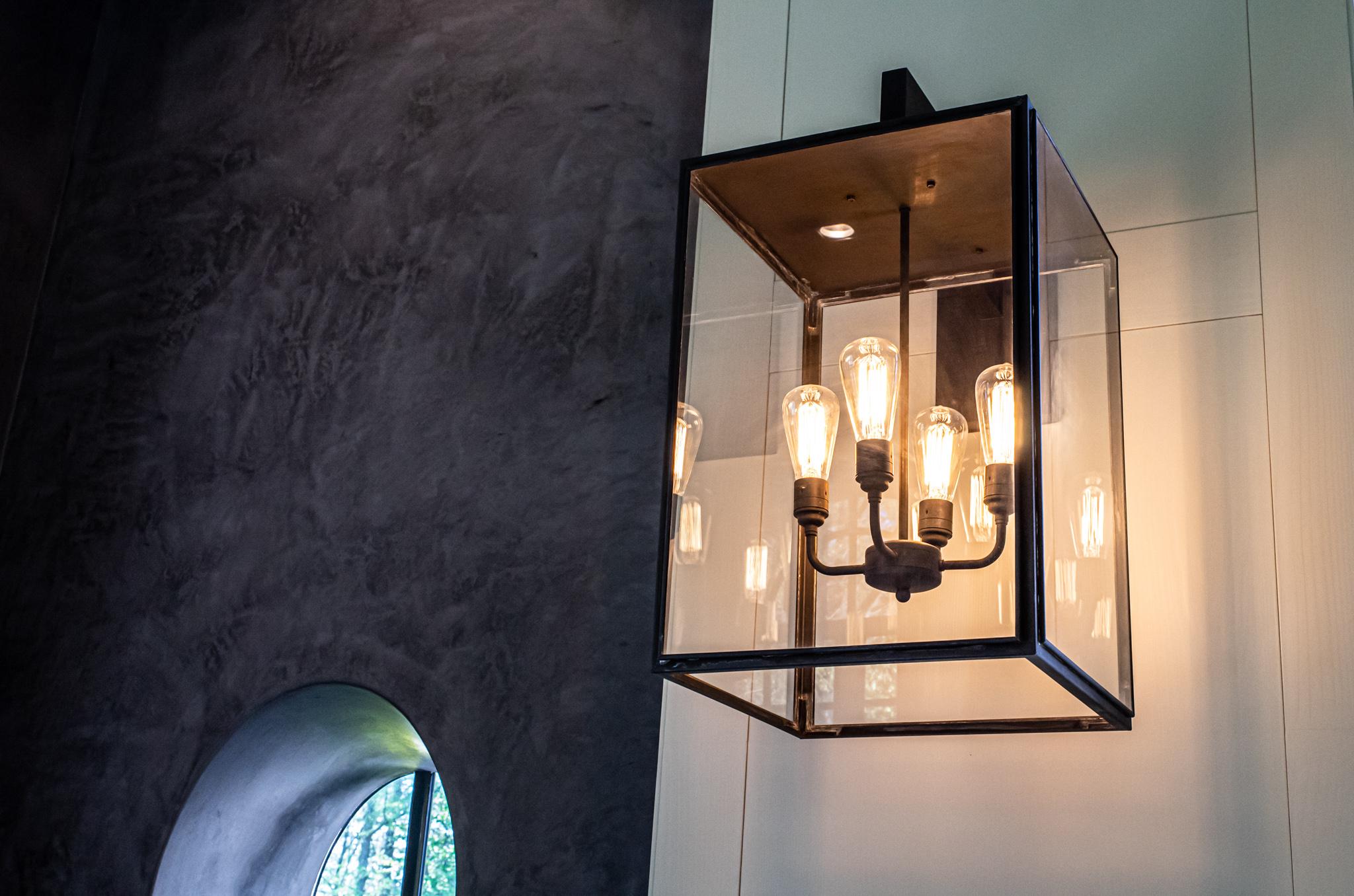 Eclectic wall light in dark bronze with outside fitted clear or frosted glass, closed top and bottom. Wall bracket in bronze lacquered inox with forcible transit. For outdoor use only (IP43).

With four-arm lamp holder, Caret Squirrel Cage lamp