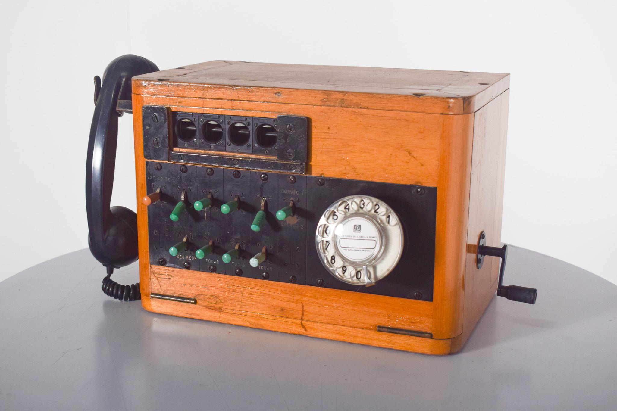 Central telefónica, PBX de los años 50/60.  Sistema telefónico manual utilizado para interconectar varias líneas en una empresa u organización. Con carcasa de madera e inserciones metálicas, auricular de baquelita negra, manivela y el clásico disco
