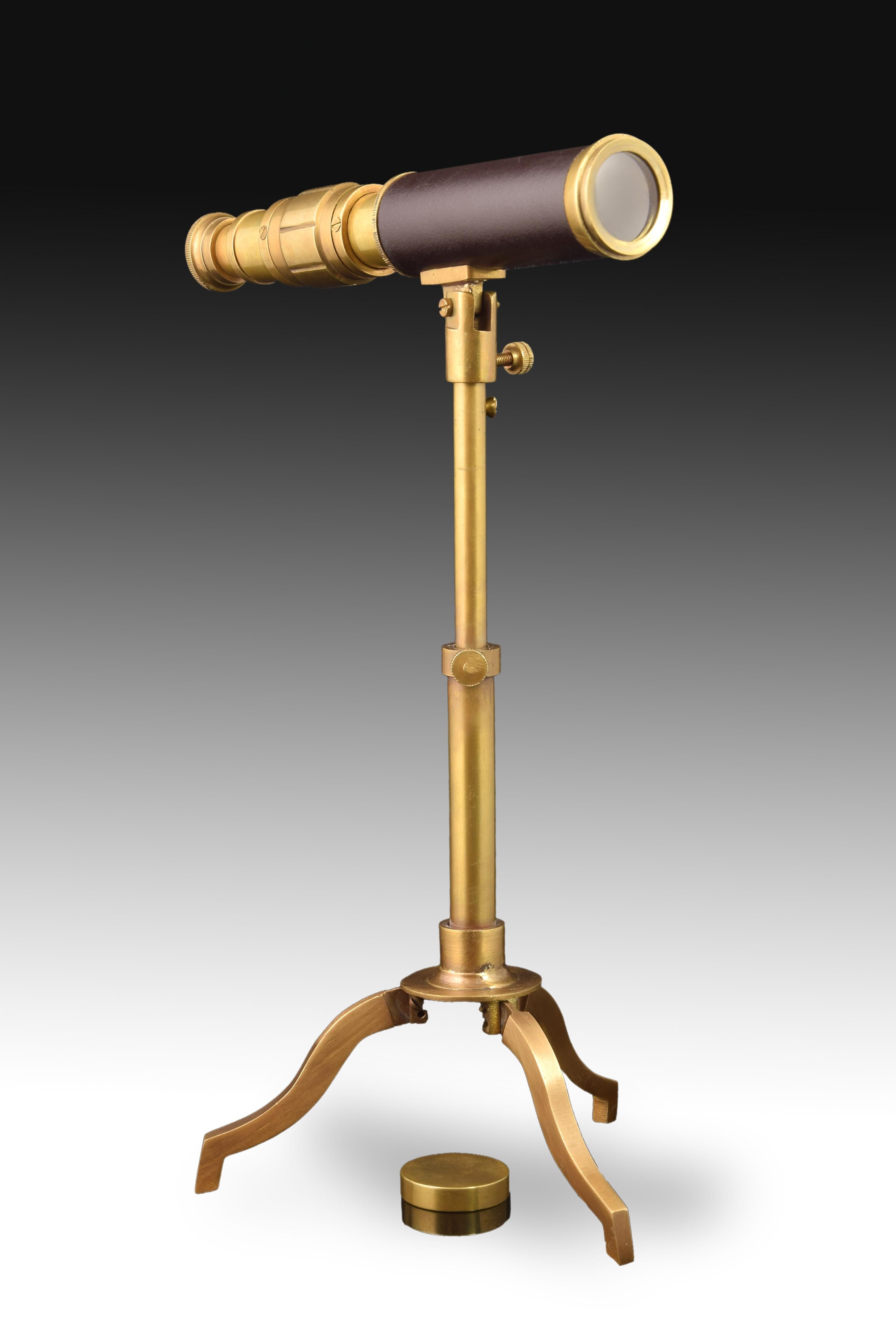 Teleskop mit Stativ. Goldmetallic-Antik-Finish 
Dekorative Verwendung, nicht funktional. 
Teleskop aus vergoldetem Metall, verziert mit einem dunklen Band, steht auf einem dreibeinigen, ebenfalls vergoldeten Metallstativ. Die Sauberkeit der Linien