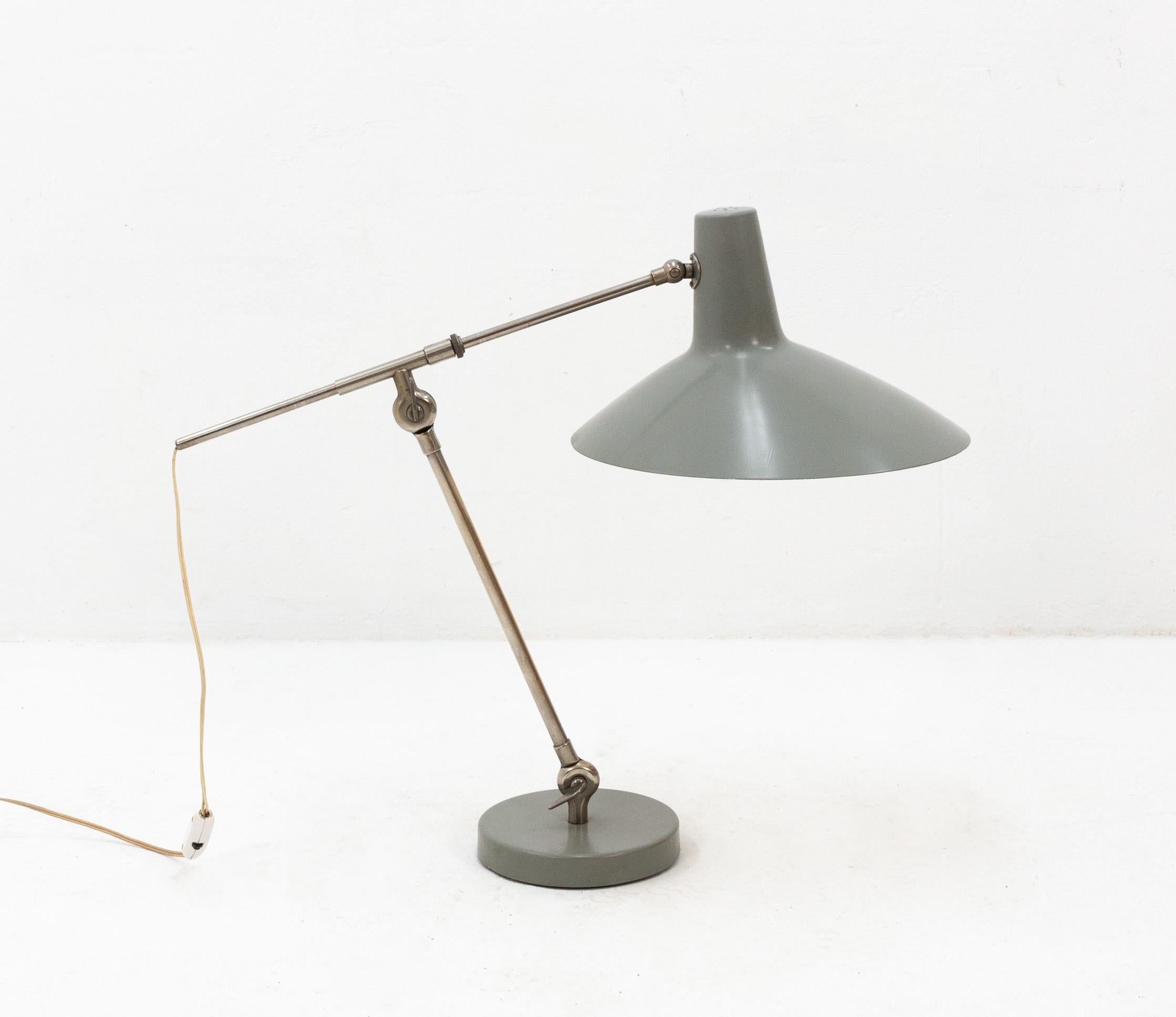 Very well designed desk lamp. Design by Floris Fideldij for Artimeta Soest Holland 1960s  featuring a nickel-plated telescoping arm on two joints and its original industrial gray paint.  Very rare lamp in good condition.
  