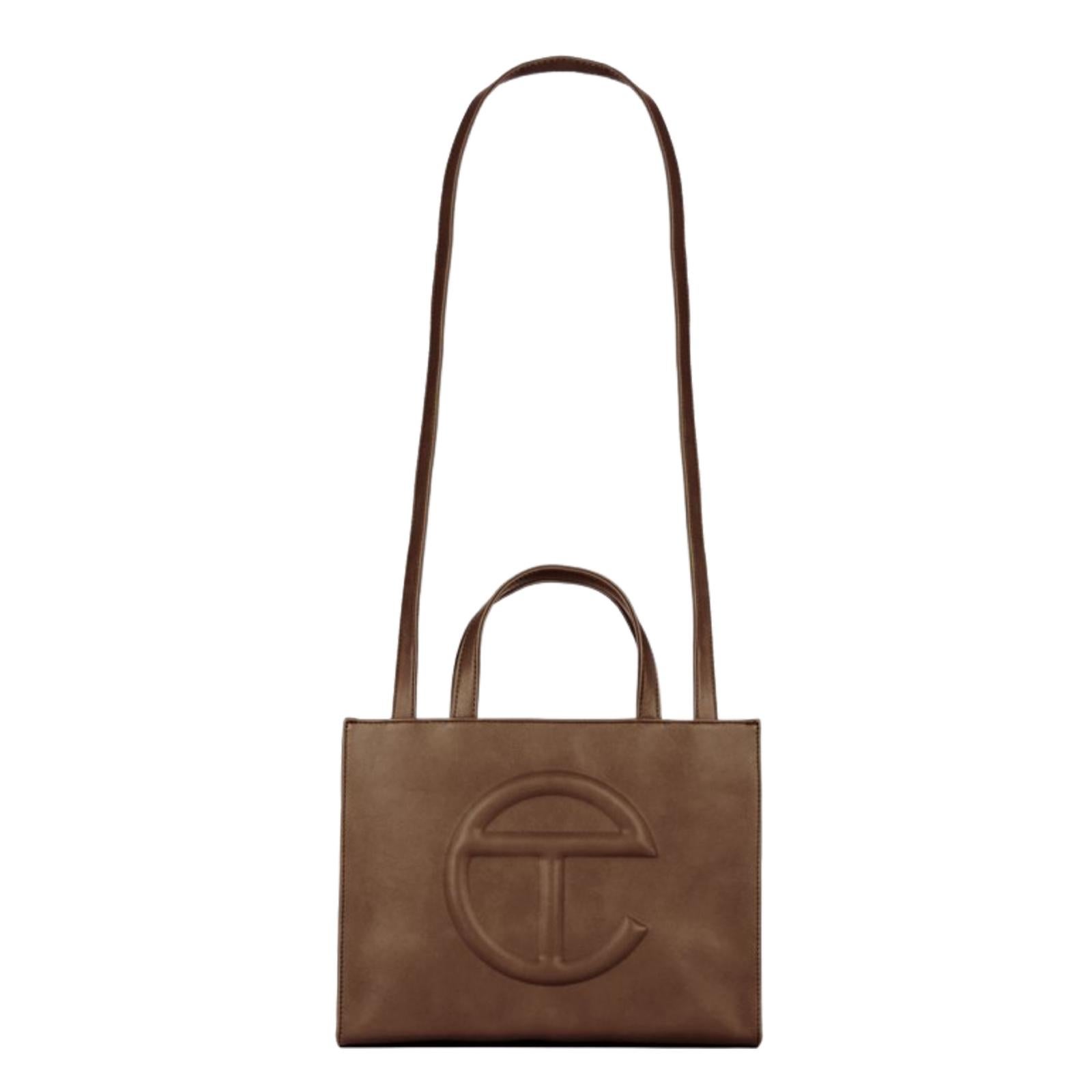 This bag is made with vegan/faux leather and twill interior lining. Featuring a double strap (handles and cross-body straps), embossed logo, and magnetic snap closure. The bag is packaged in a 100% cotton drawstring dust bag with screenprinted logo.