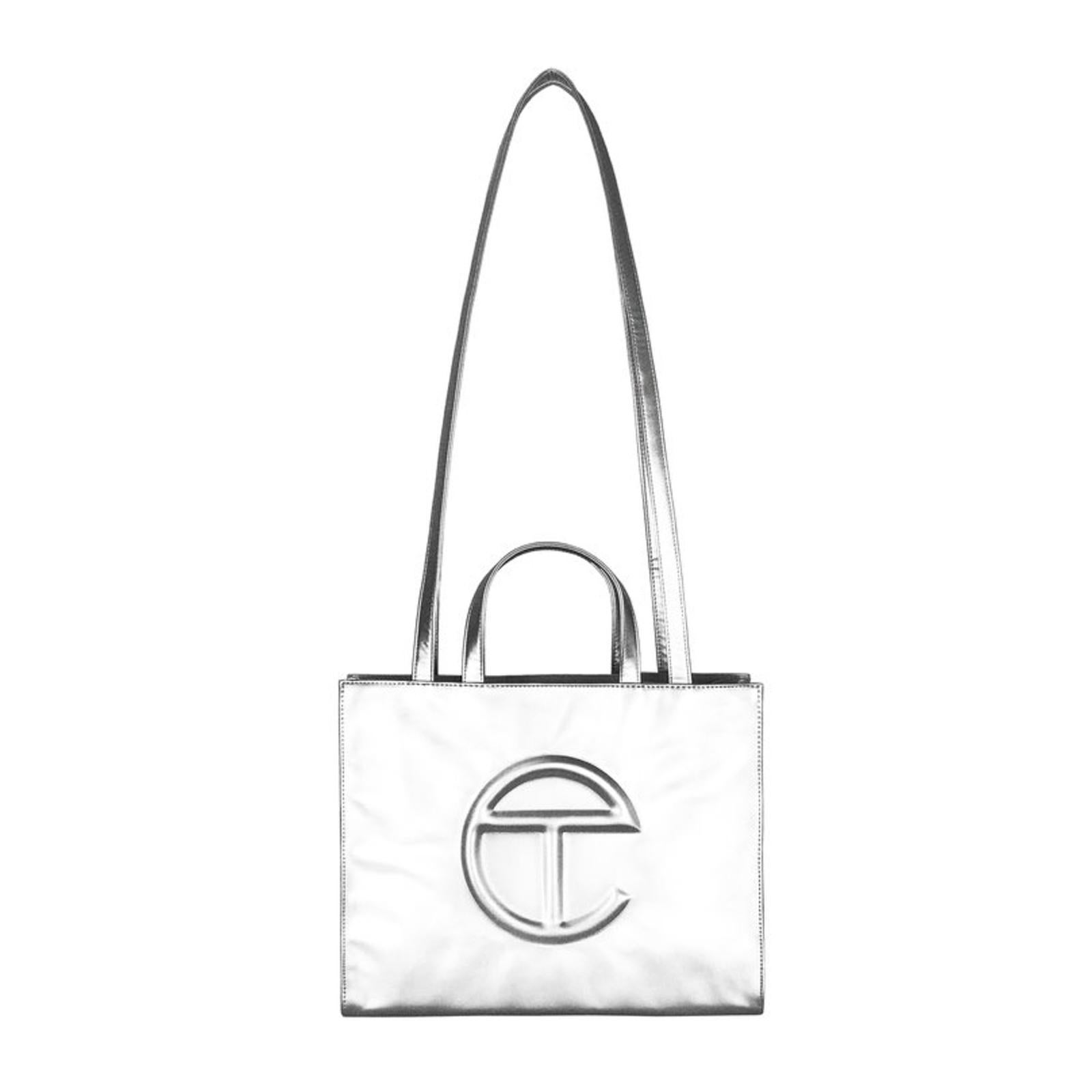 This bag is made with vegan/faux leather and twill interior lining. Featuring a double strap (handles and cross-body straps), embossed logo, and magnetic snap closure. The bag is packaged in a 100% cotton drawstring dust bag with screenprinted logo.