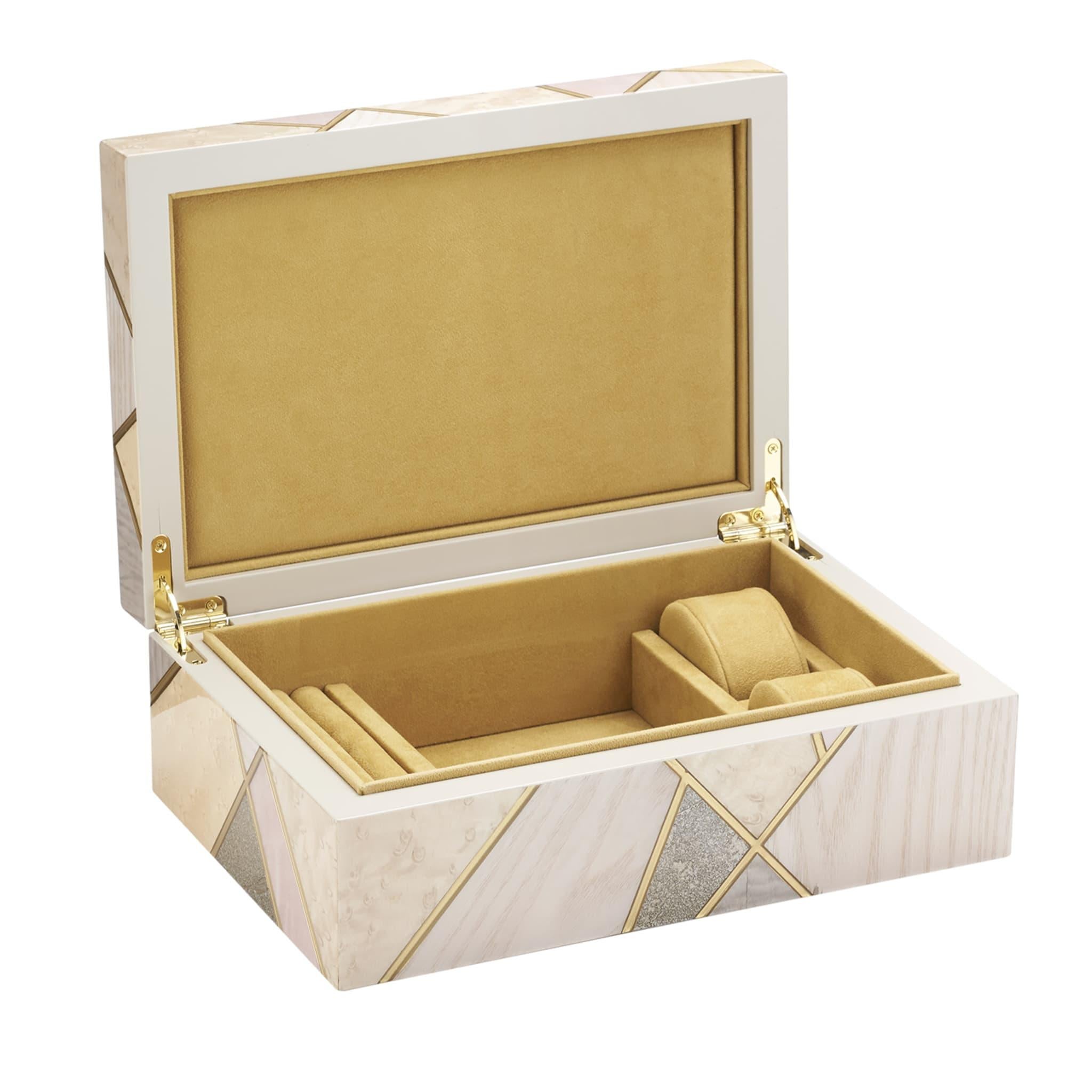 Cette boîte à bijoux, unique et réalisée de main de maître, est un triomphe d'incrustations de bois précieux de bolivar, de frêne, de palissandre et d'ébène rendues féminines par une palette de tons délicats de beige et de rose. Des profils dorés