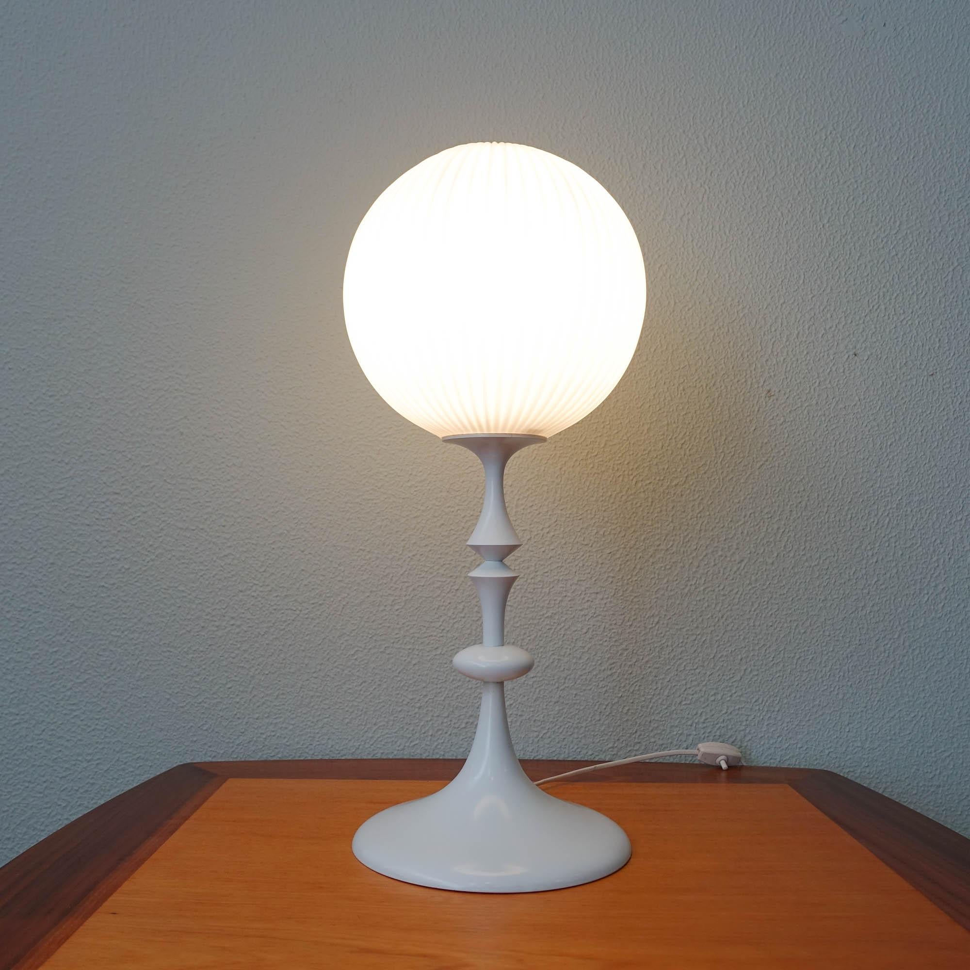 This table lamp was designed and produced by Temde Leuchten,  in Switzerland, during the 1960's, in Max Bill style. It has a tulip shape base in white enameled steel with wooden decoration, and a white pleated milk glass, which spreads the light
