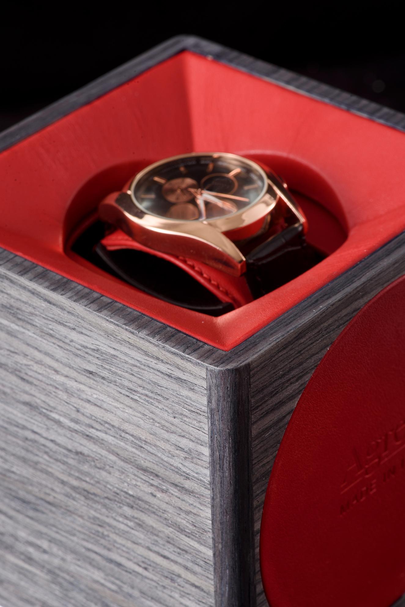 
 Winder for automatic watch in smoke grey oak. Red leather lining, swiss-made mechanics with touch power, battery operated.