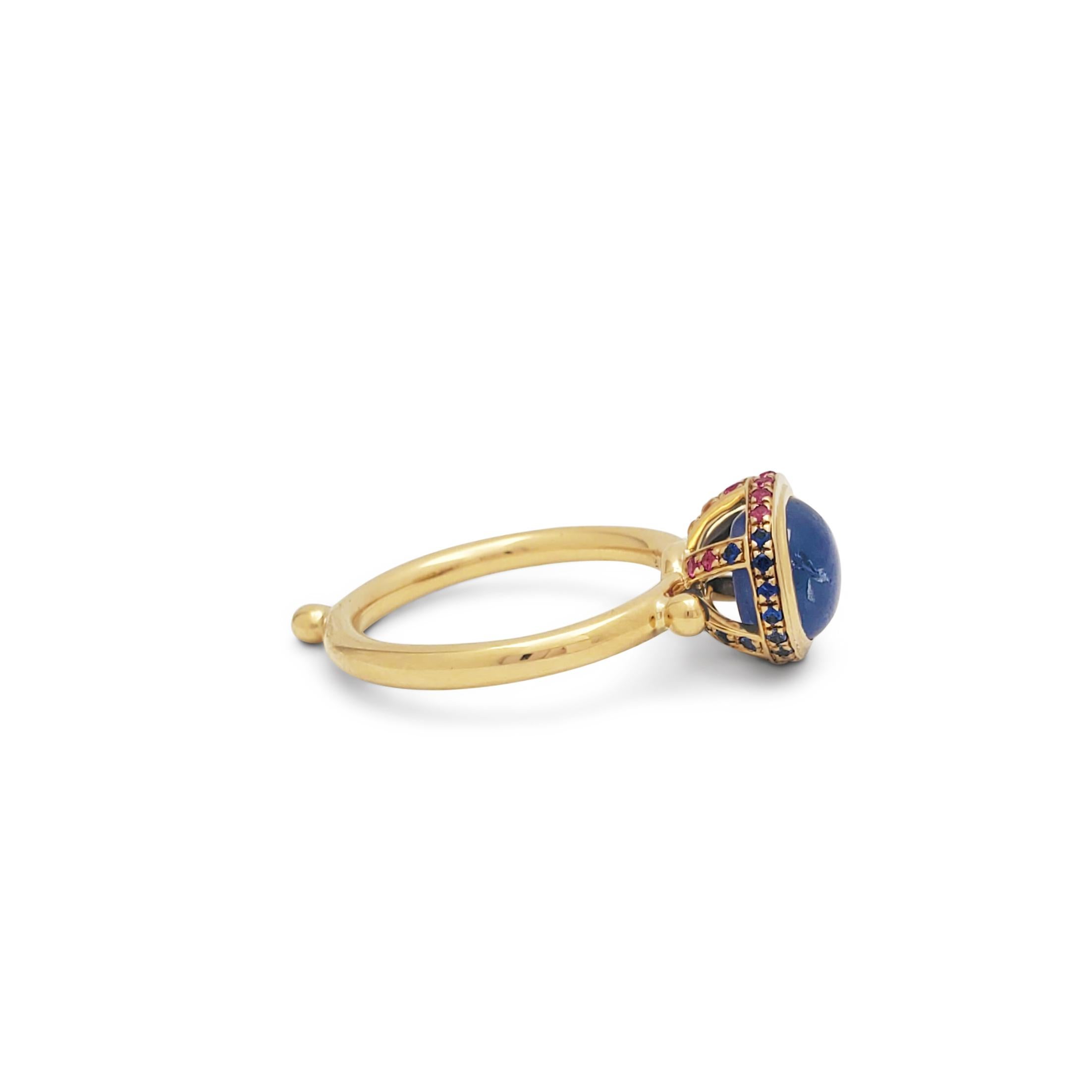 Authentic Temple St. Clair ring crafted in 18 karat yellow gold.  A bezel set cabochon iolite sits at the center of the ring surrounded by a basket of multicolor gemstones.  Size 5.  Stamped 750 and signed with the Temple St. Clair maker's mark. 
