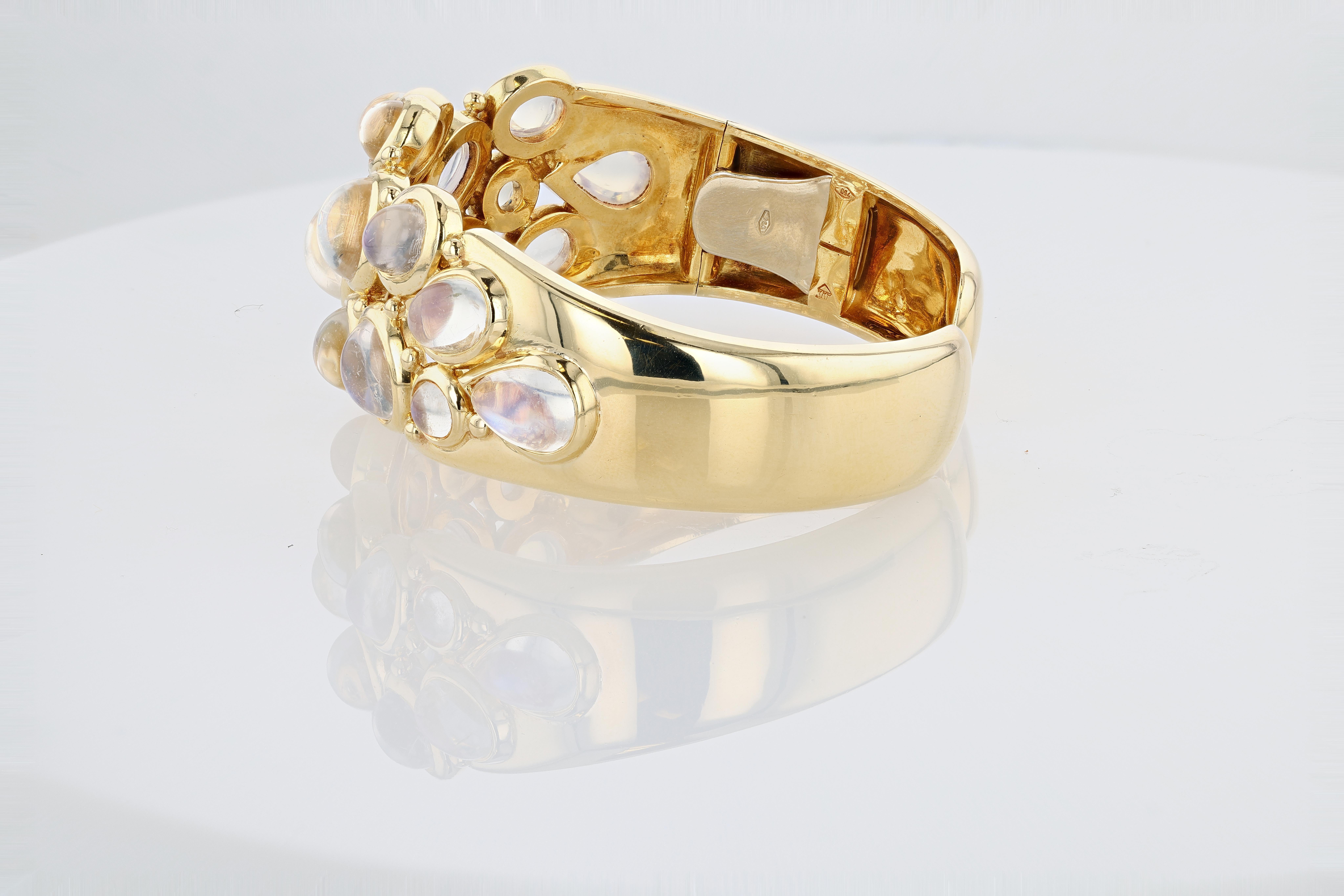 A highly ornate and exceedingly rare 18 karat yellow gold and royal blue moonstone cuff bracelet by contemporary jewelry designer Temple St. Clair, featuring no less than 18 round, oval, and pear shaped cabochon moonstones bezel set. The bracelet