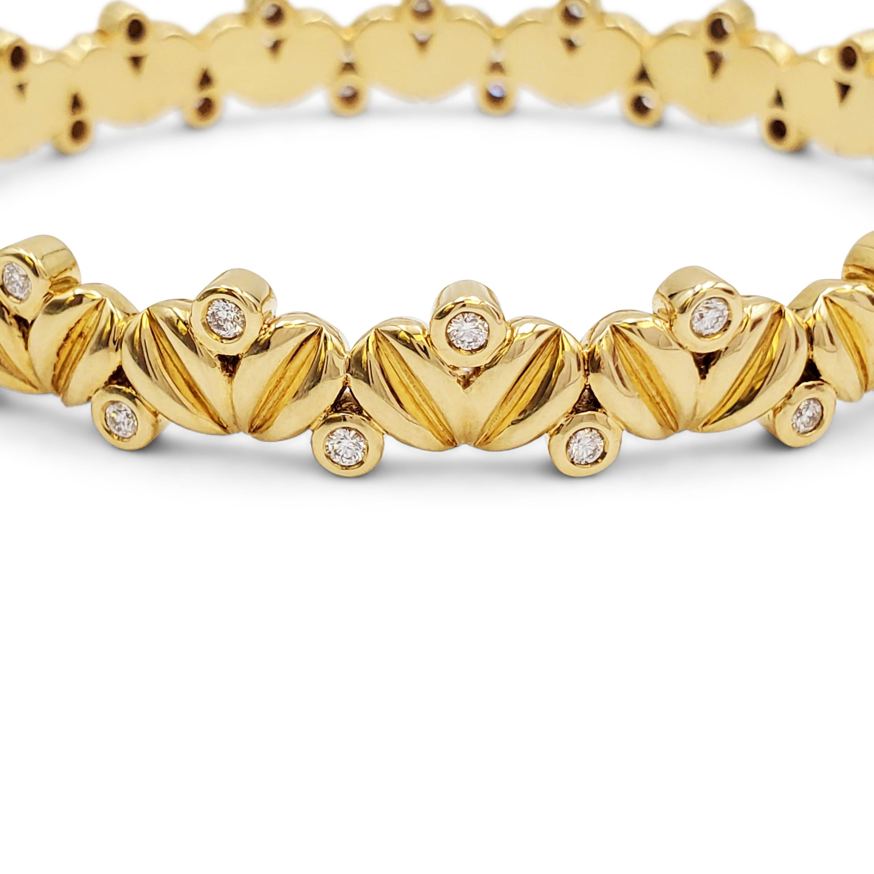 Authentic Temple St Clair bracelet crafted in 18 karat yellow gold.  A pattern of carved seeds is accented by bezel set diamonds of approximately 1 carat total weight.  The bracelet has an internal circumference of 6 3/4 inches and measures 9.3mm in