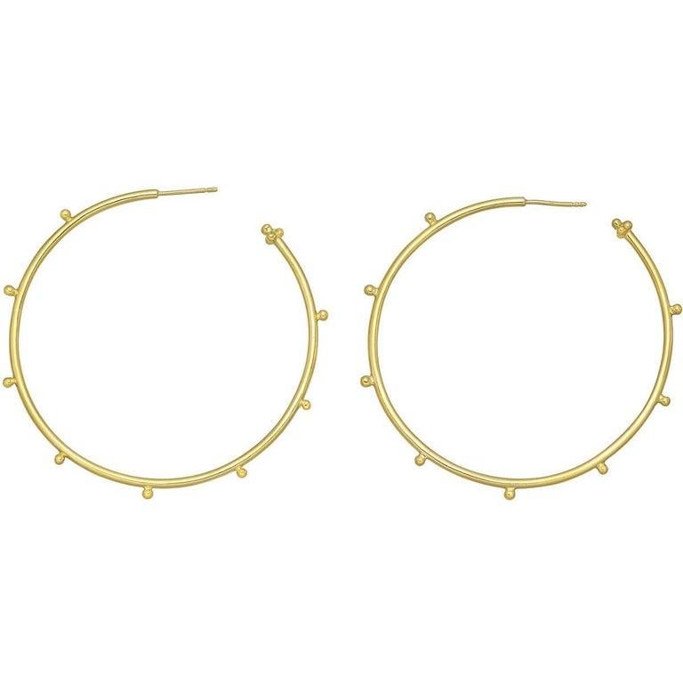 Round-shaped granulated hoop earrings in polished 18k yellow gold, designed by Temple St. Clair. Posts with friction backs for pierced ears. Just over 2