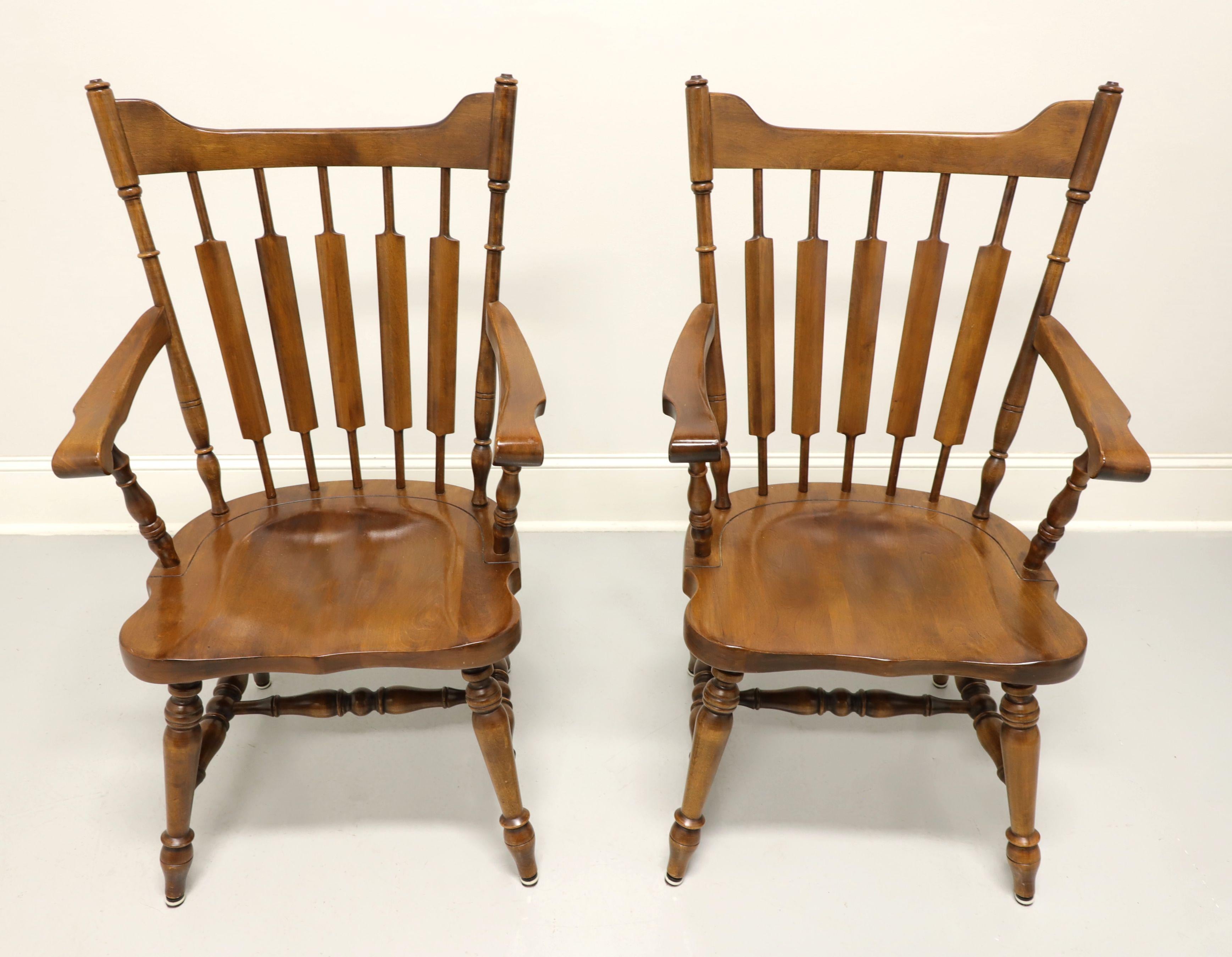 A pair of Early American Windsor style dining armchars by Temple Stuart, their 829 Rockingham. Solid maple with carved crestrail, cattail spindles backrest, curved arms, saddle shape seat, turned legs and stretchers. Made in the USA, in the late