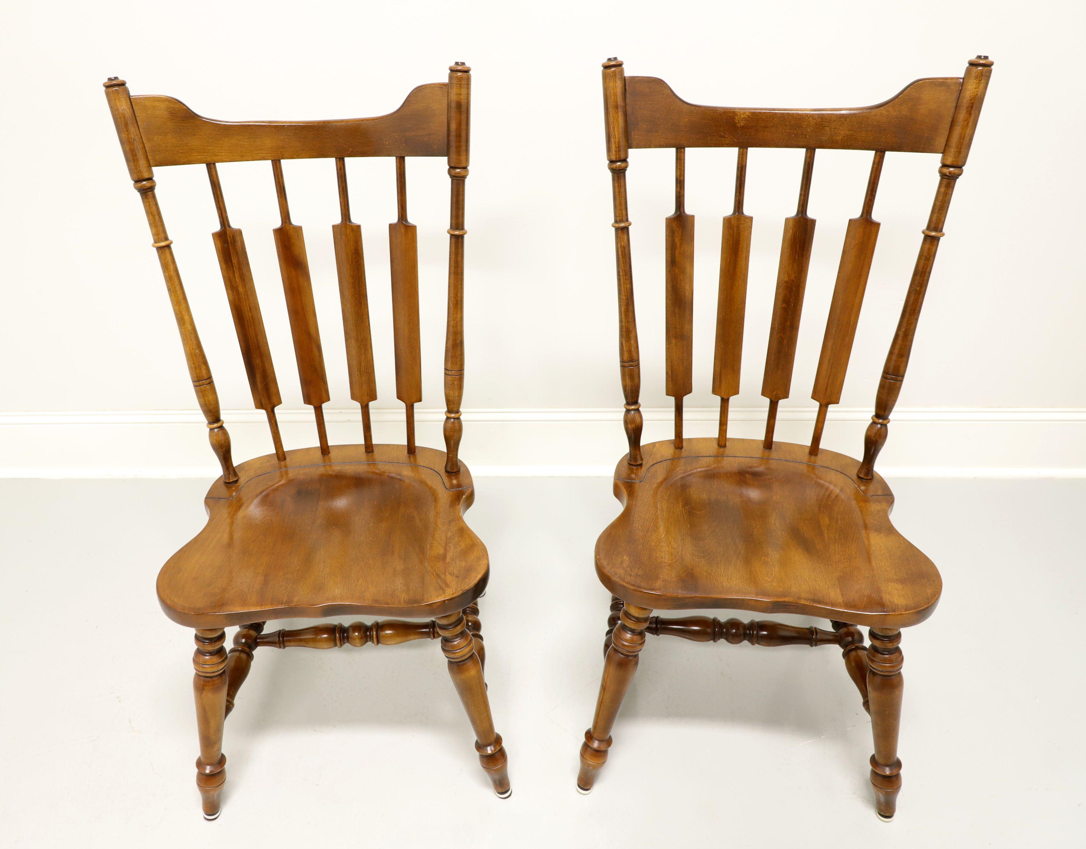 A pair of Early American Windsor style dining side chars by Temple Stuart, their 829 Rockingham. Solid maple with carved crestrail, cattail spindles backrest, saddle shape seat, turned legs and stretchers. Made in the USA, in the late 20th
