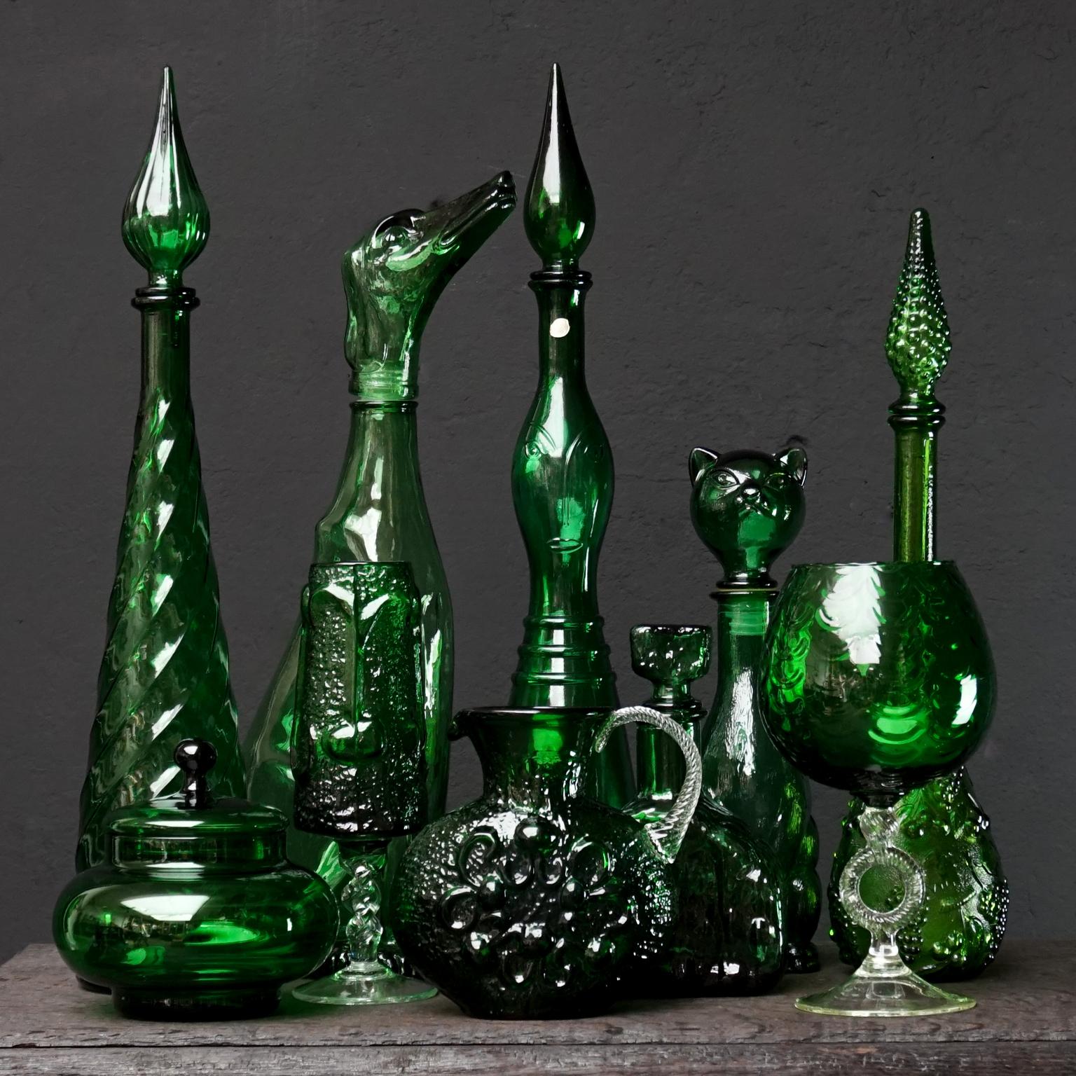 Spectacular set of ten 1960s green Italian Empoli pressed and blown glass. Three genie bottles, a large dog shaped bottle and a cute cat shaped one. A large goblet, a high glass and pitcher by Wayne Husted. A Brutalist 'rock' shaped decanter a last