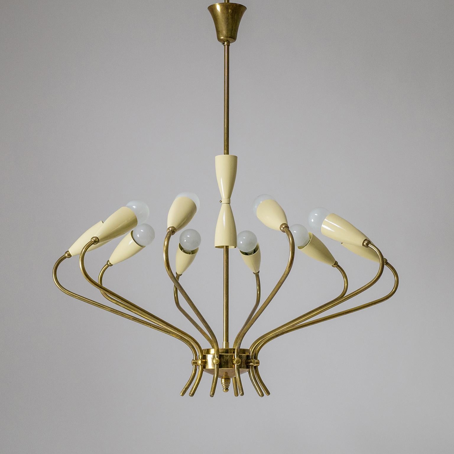 Beautiful crown shaped brass chandelier attributed to Lumi Milano, 1950s. Very unique design with ten sensuously curved brass arms, each with a cream colored aluminum cup and an original E14 socket. Very fine build quality with thick and sturdy