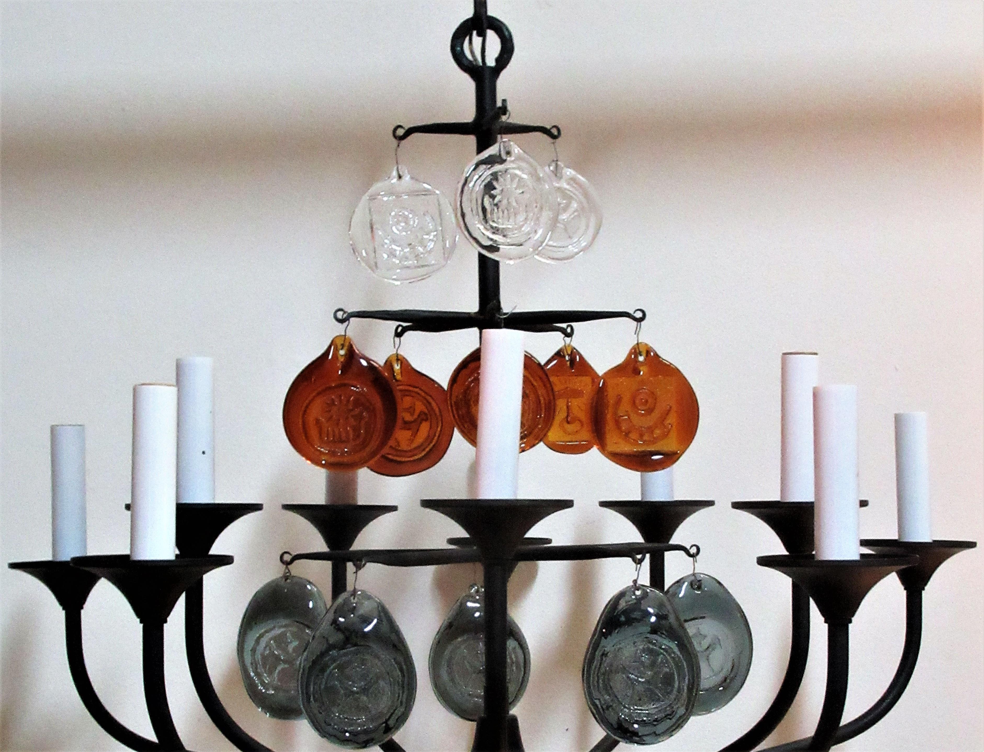 1950's Danish black iron Viking chandelier with ten candle armatures by Svend Aage Sorensen for Holm Sorensen Co. Denmark. There are three rows of decorative glass roundels depicting Nordic designs in relief ( total thirteen roundels ) The three top