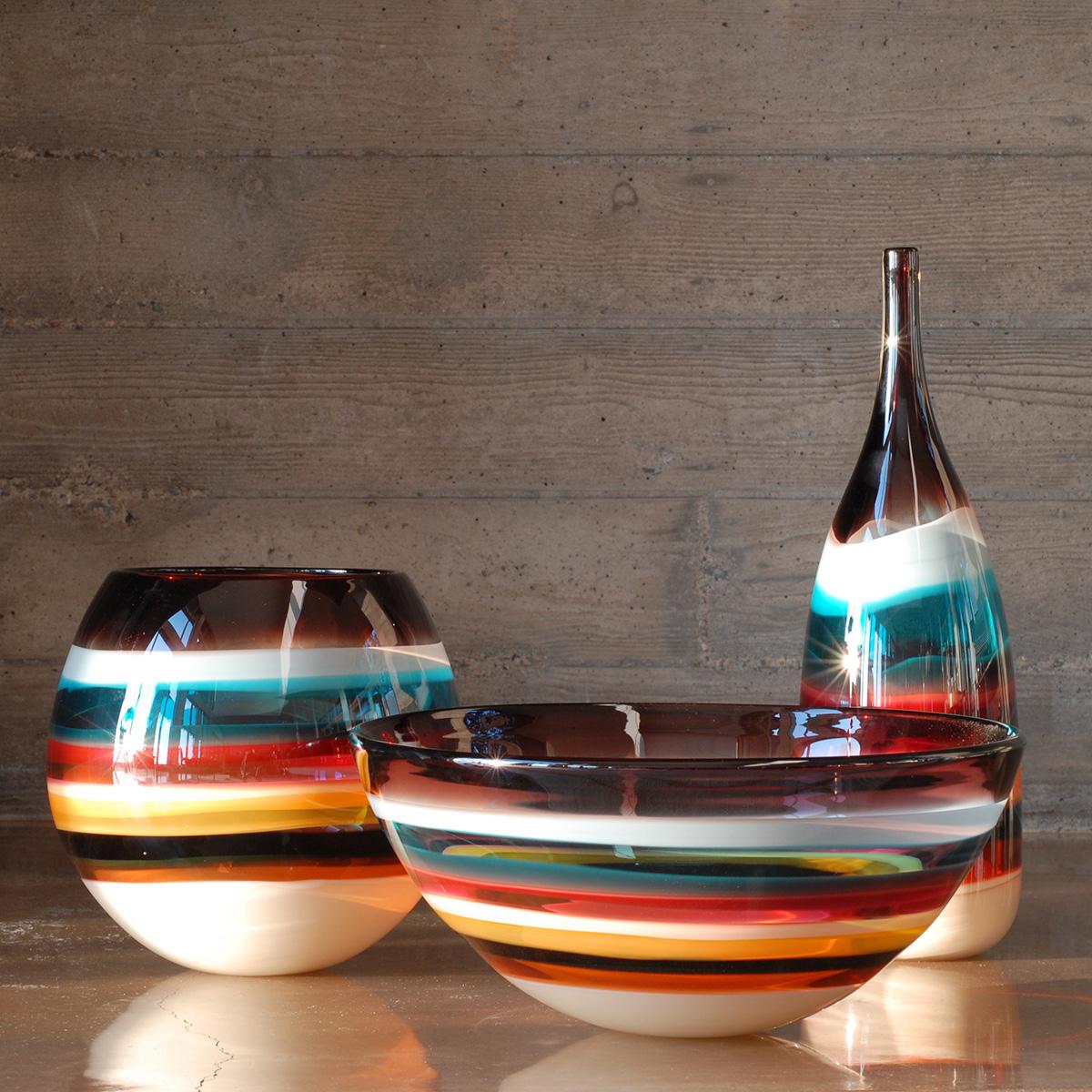 These striking pieces draw inspiration from the rich hues and undulating topography of Southern California. Alternating layers of opaque and transparent colors are applied to clear glass. Overlaps create opportunities for new colors to be formed,