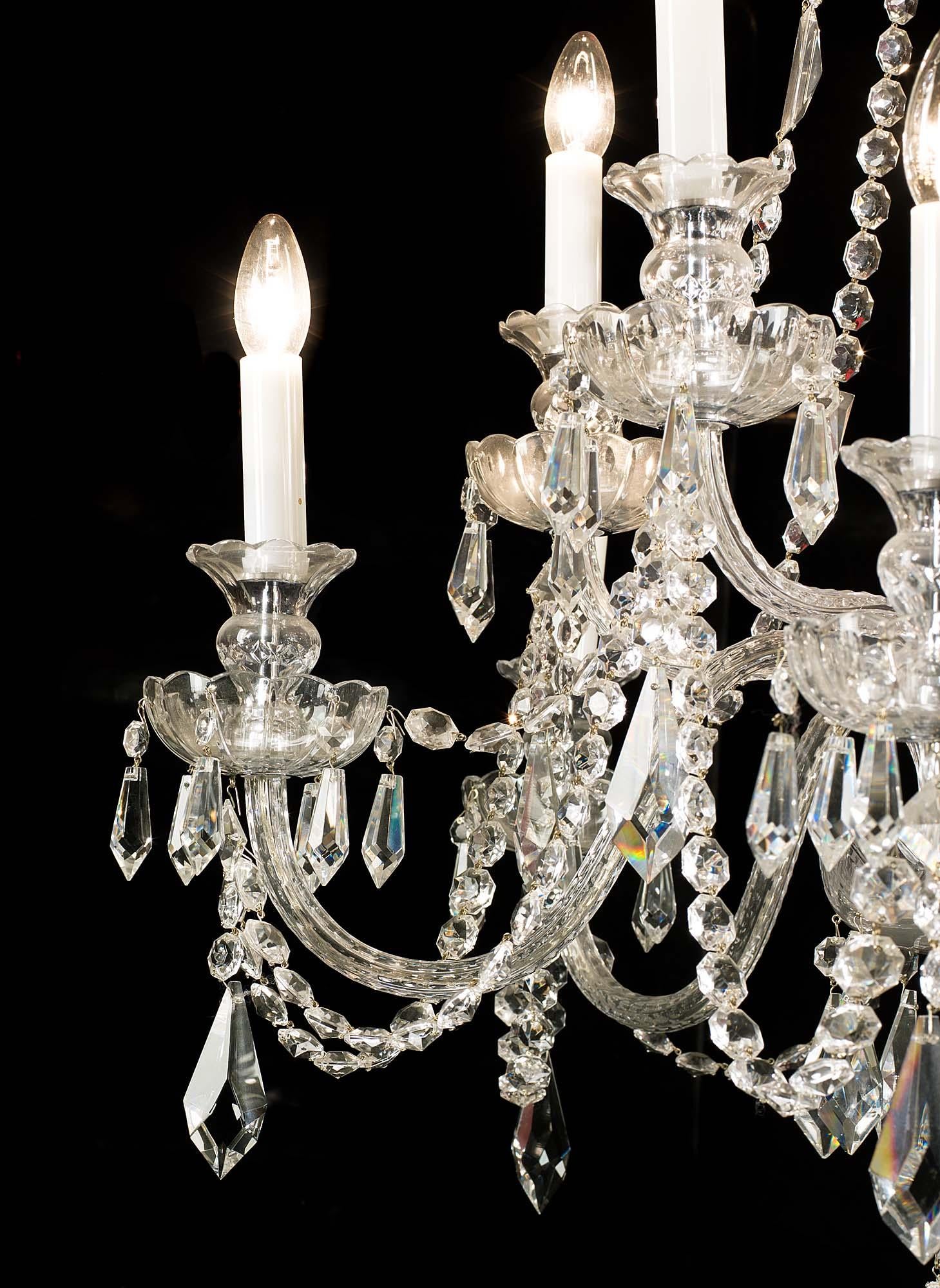 A ten branch cut-glass chandelier, with shaped baluster stem issuing two graduated tiers of swan neck branches, all with lustre drip pans interlinked with cut glass chains.
Late 20th century.