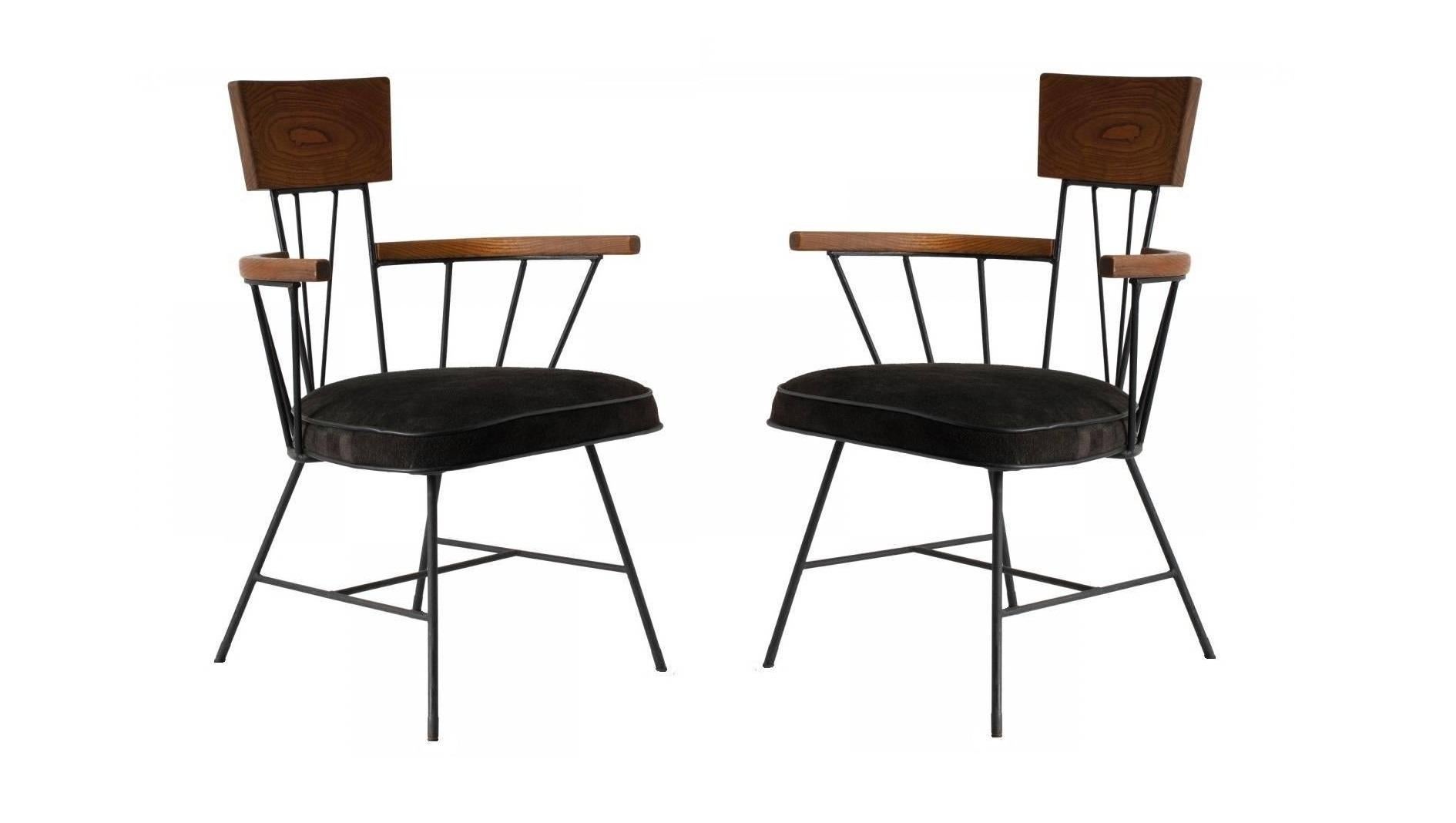 A unique set of ten dining chairs designed by Richard McCarthy and manufactured by Selrite. The black painted iron against the smooth grain of the wood perfectly embodies the Industrial feel of the era. Consists of eight arm and two armless chairs.