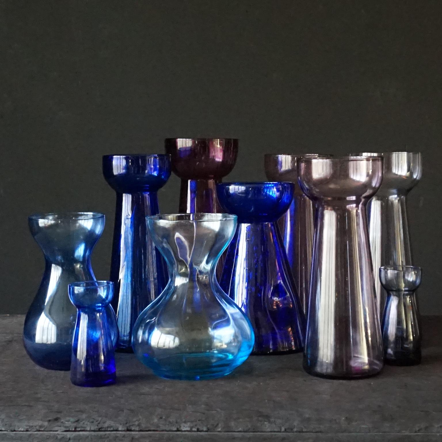 10 blue and violet flower bulb hyacinth, daffodil, tulip and crocus vases.
All clear hand blown glass in blue and purple tones by Royal Crystal Leerdam and by Rimac Baarn. 8 big ones and 2 small ones

Ribbed purple high glass by Rimac 22cm high, Ø