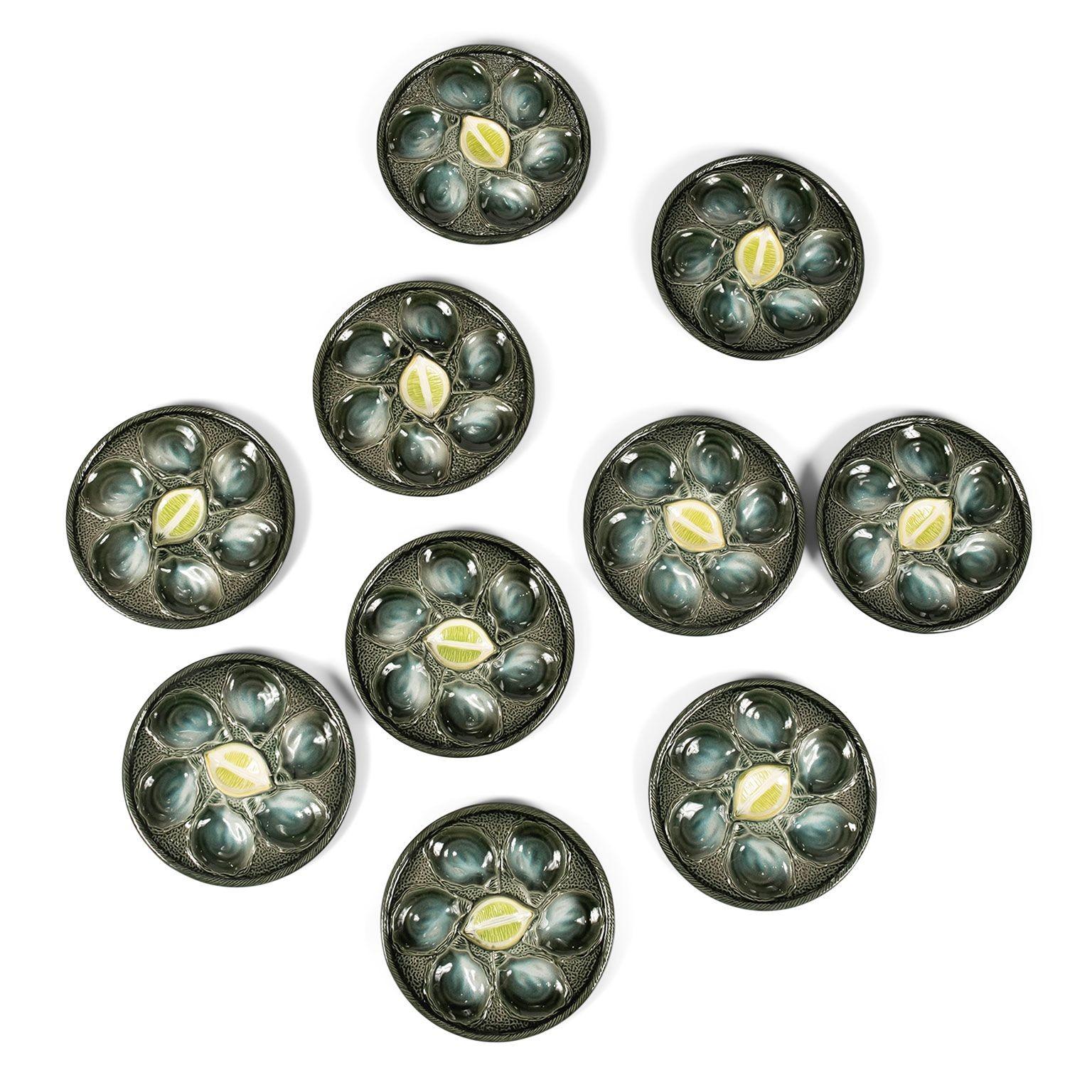 Dix assiettes à huîtres en majolique émaillée St. Clément. Circa 1920-1929, France. Plaques d'huîtres au centre au citron. Marqué avec le numéro de moule. Vendu ensemble. Le prix est de 2 600 dollars pour un jeu de dix.