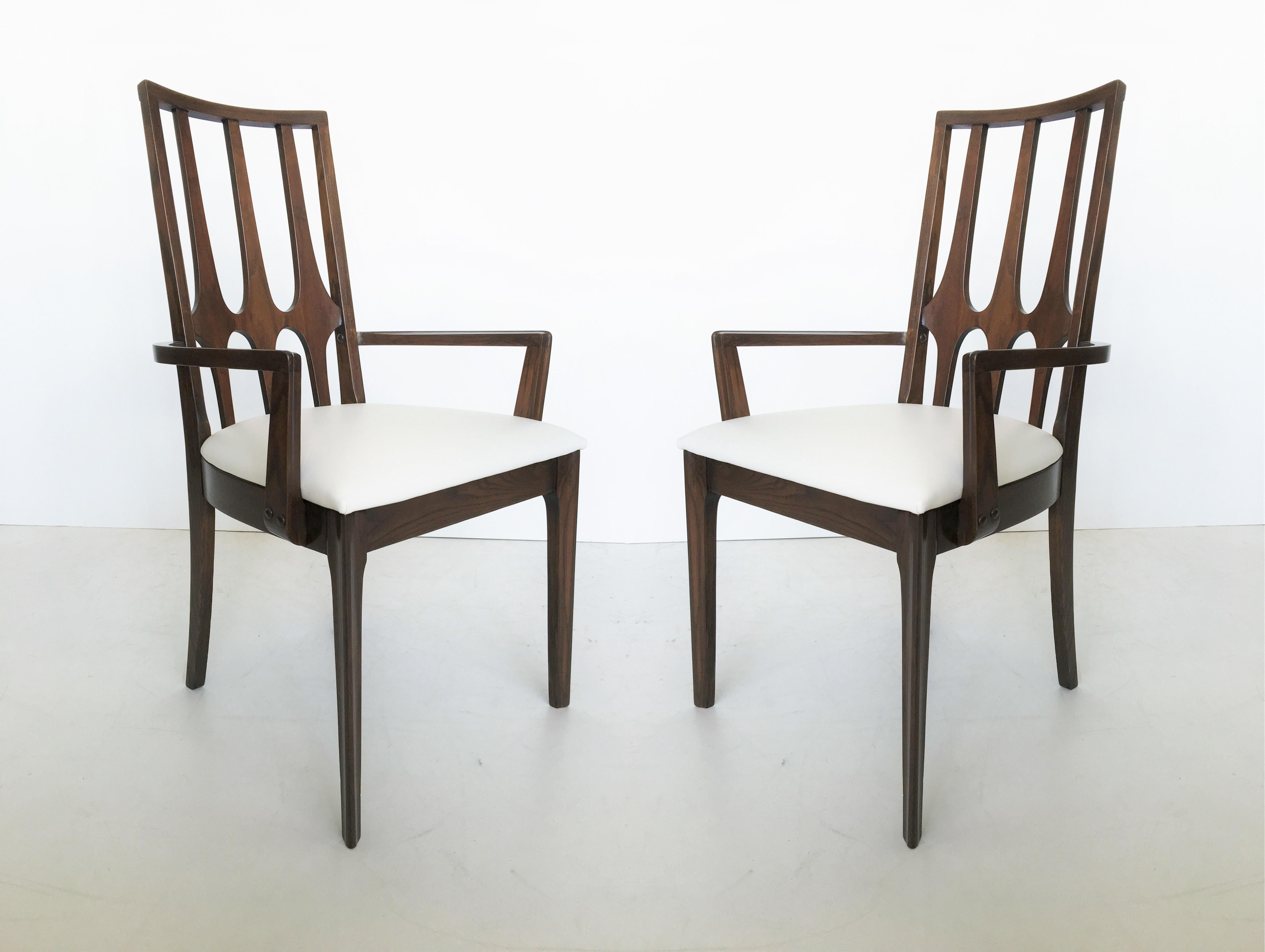 Set of 10 vintage walnut dining chairs manufactured by Broyhill for the Brasilia collection, circa early 1960s. The chairs feature Oscar Niemeyer’s sculptural curved backs. The ten chairs consist of 8 armless chairs and 2 armchairs with straight