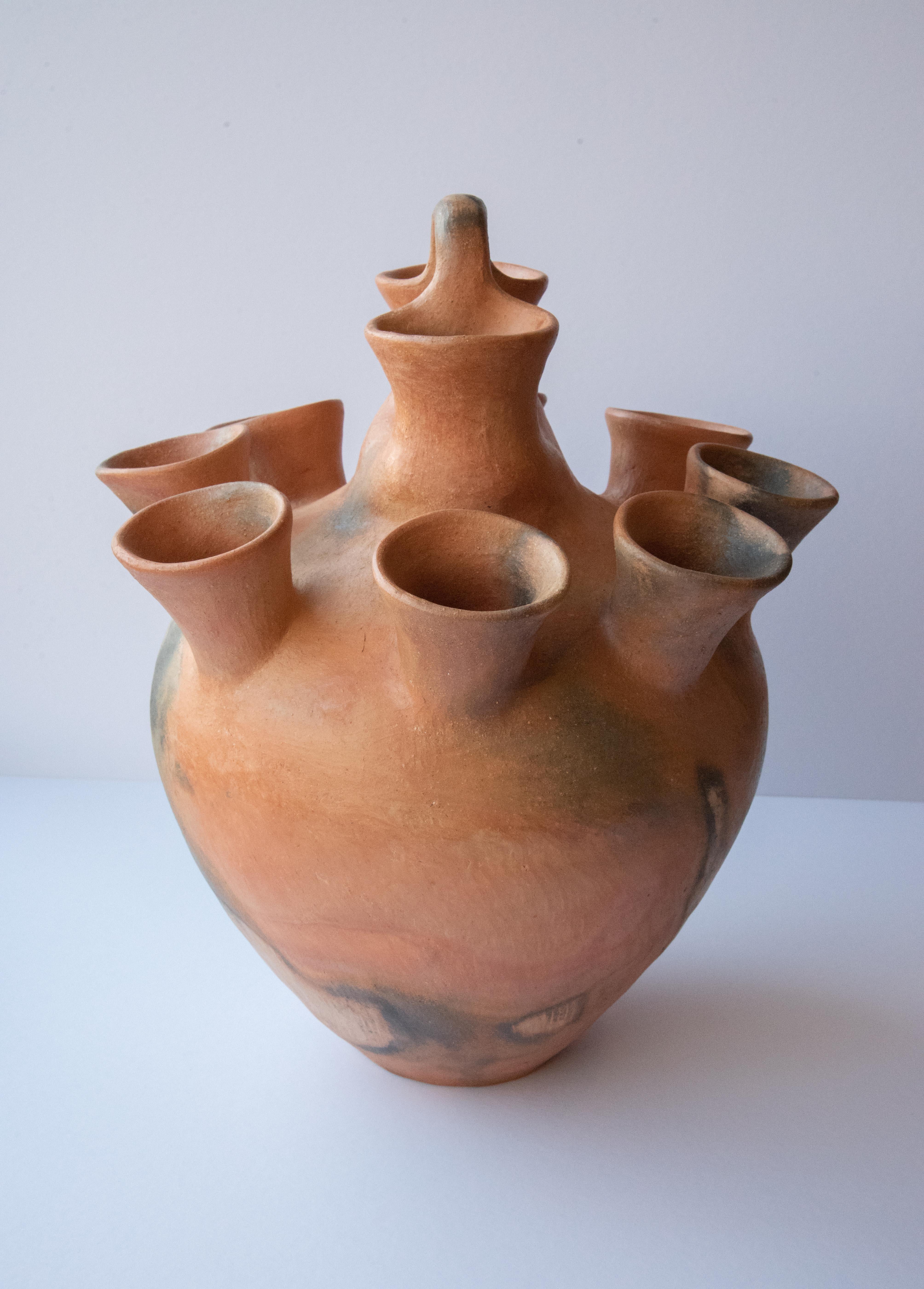 This beautiful ten mouth vessel is made in natural clay from the Sierra Norte Mountains, in Oaxaca. Cooked in Silvia Martinez's home-made oven made up of bricks, the piece is naturally burned with beautiful dark stains that give it a twist of