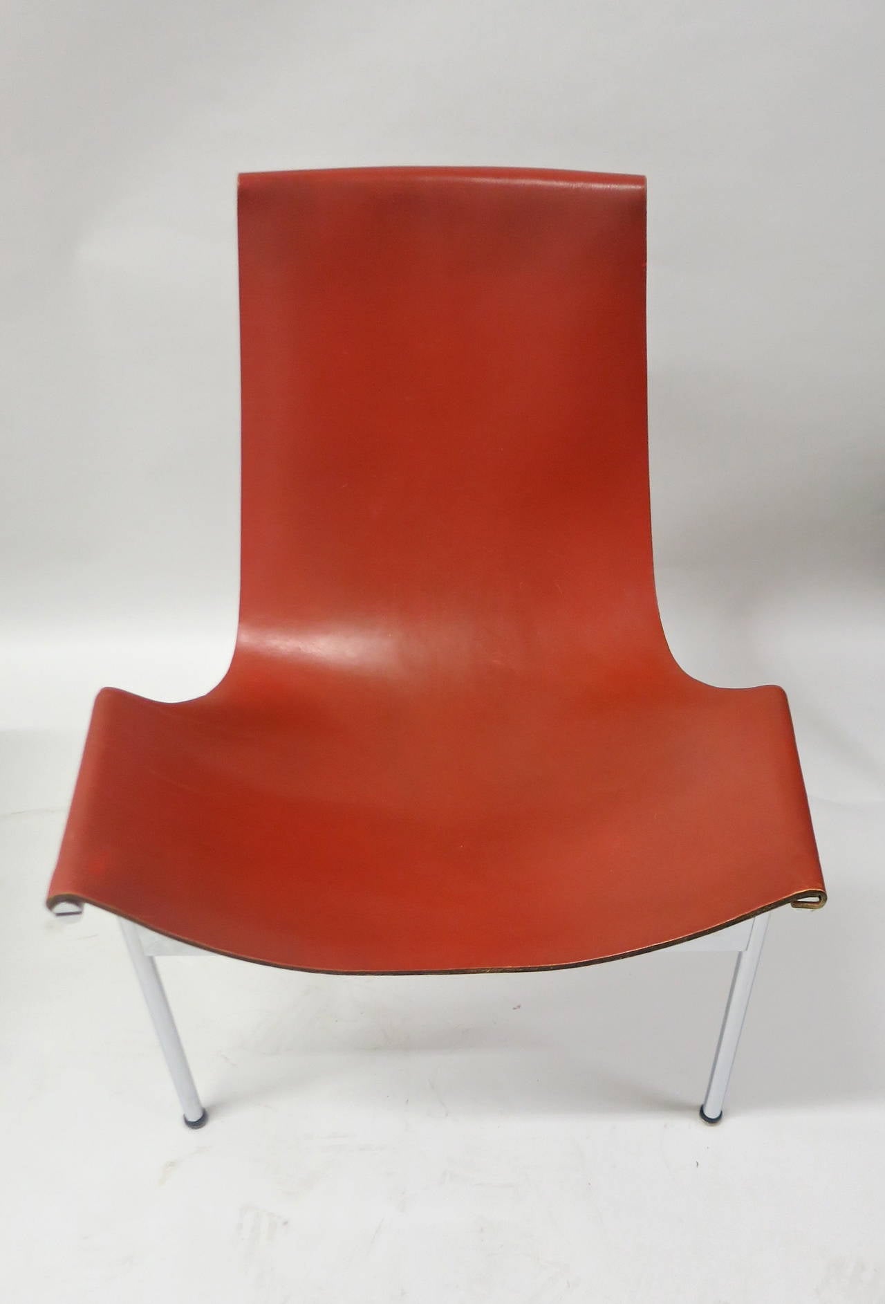 Rare set of ten T-chairs with special ordered leather backing that is in a matching tone as the front red-brown saddle leather. All have minimal wear and have had very careful use. The chromed bases are in very good to excellent-vintage condition.